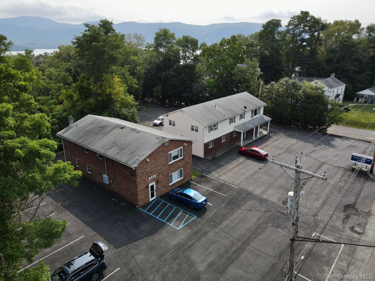 Aerial view of property and surrounding area with a mountain backdrop.