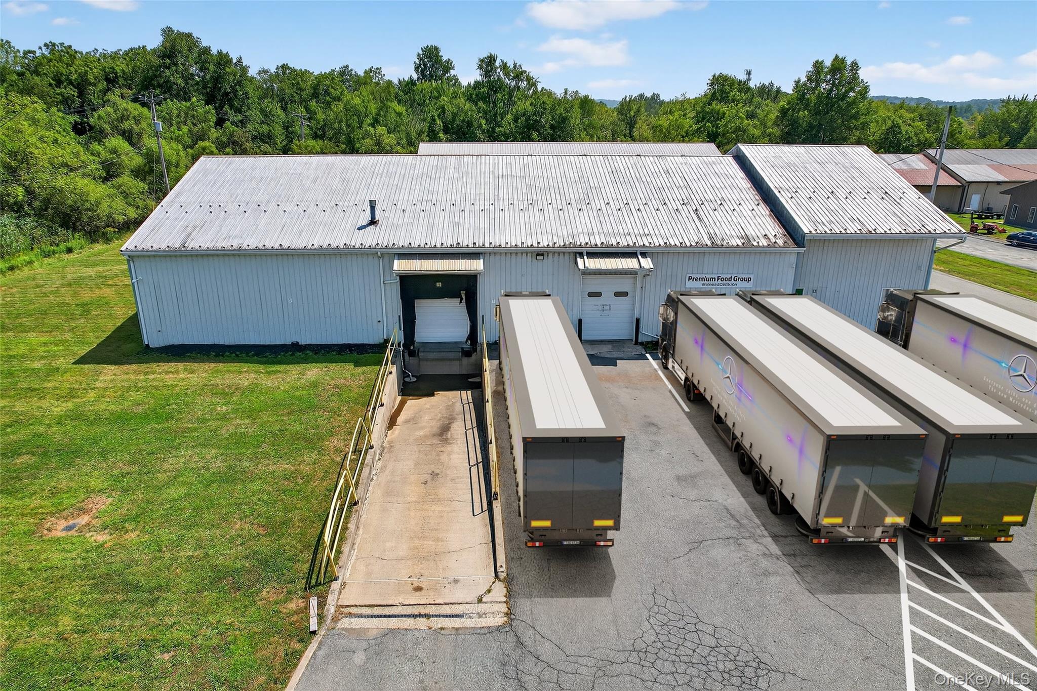 Back of property featuring a metal roof, a pole building, an outbuilding, and uncovered parking