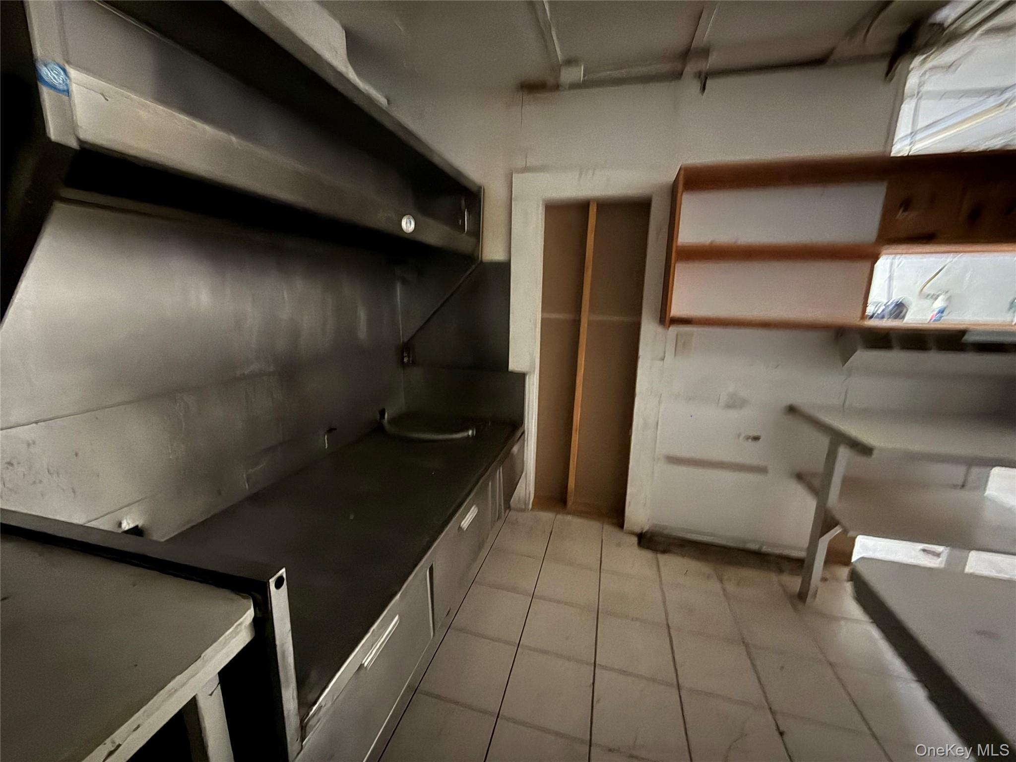 Kitchen with dark countertops and wall chimney exhaust hood