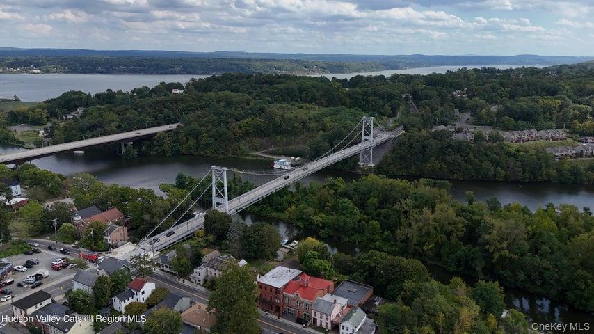 Aerial view of property and surrounding area with a large body of water and a notable bridge