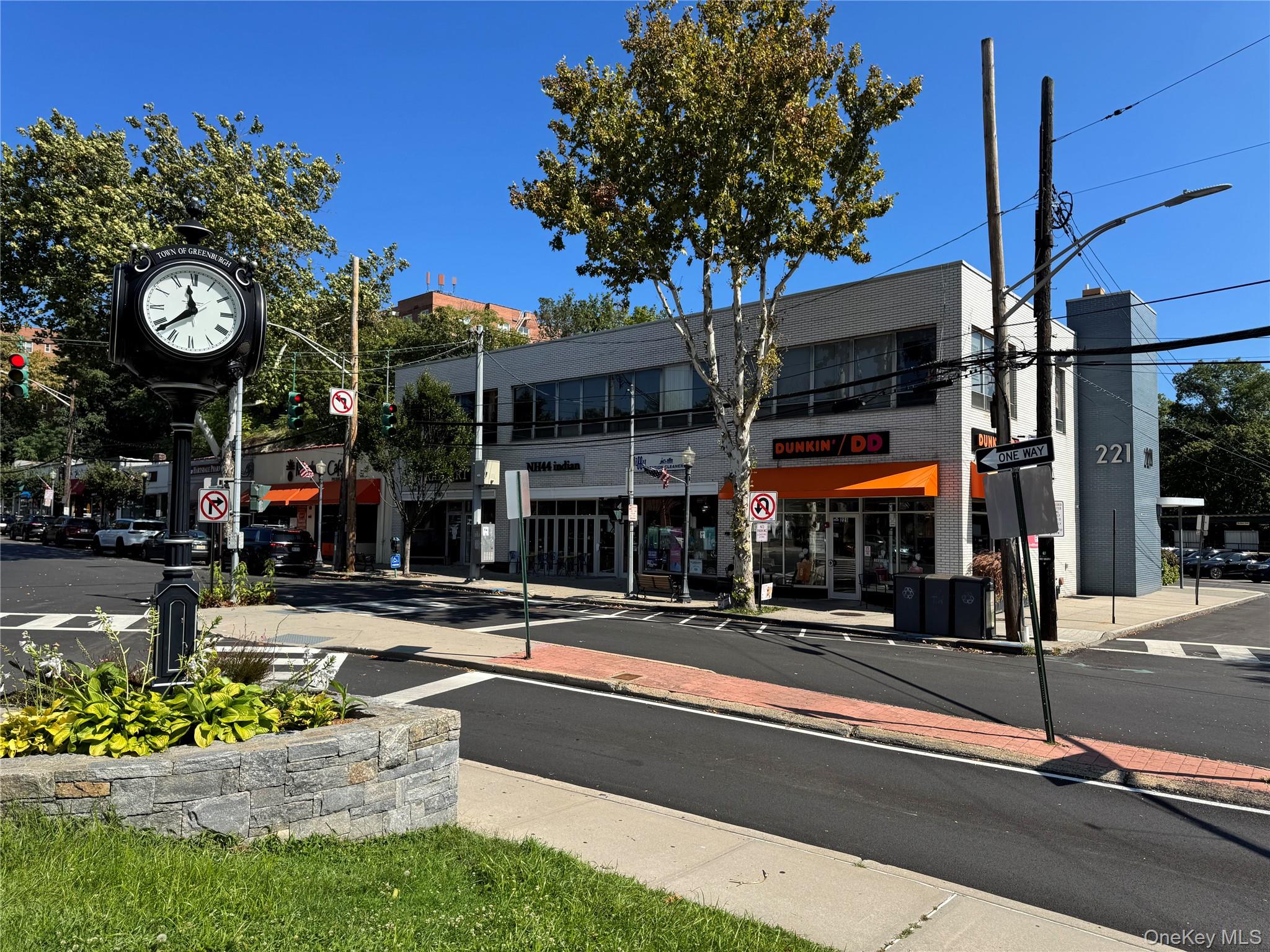 View of asphalt road with street lights, traffic signs, curbs, and sidewalks