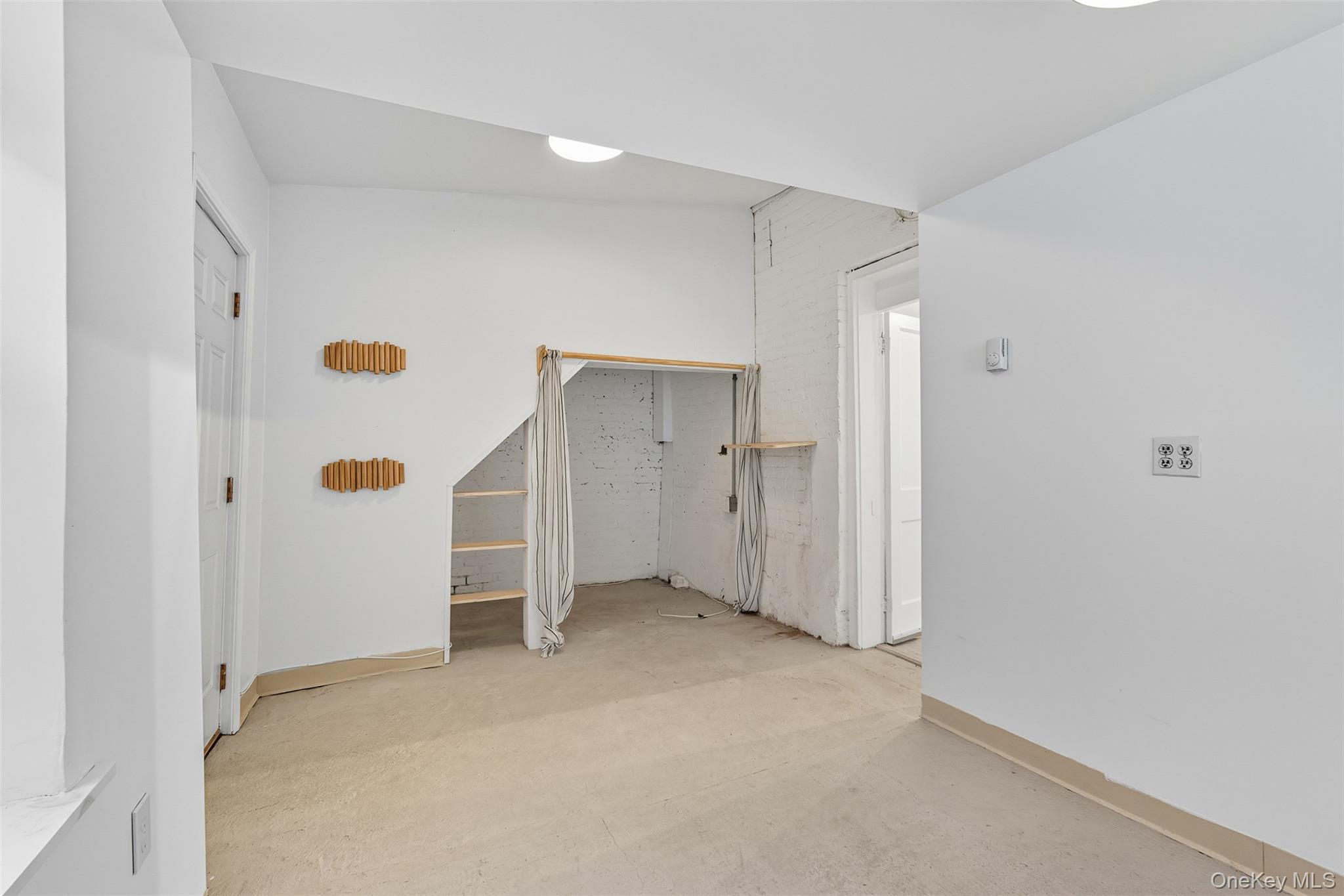 Unfurnished room with baseboards and concrete flooring