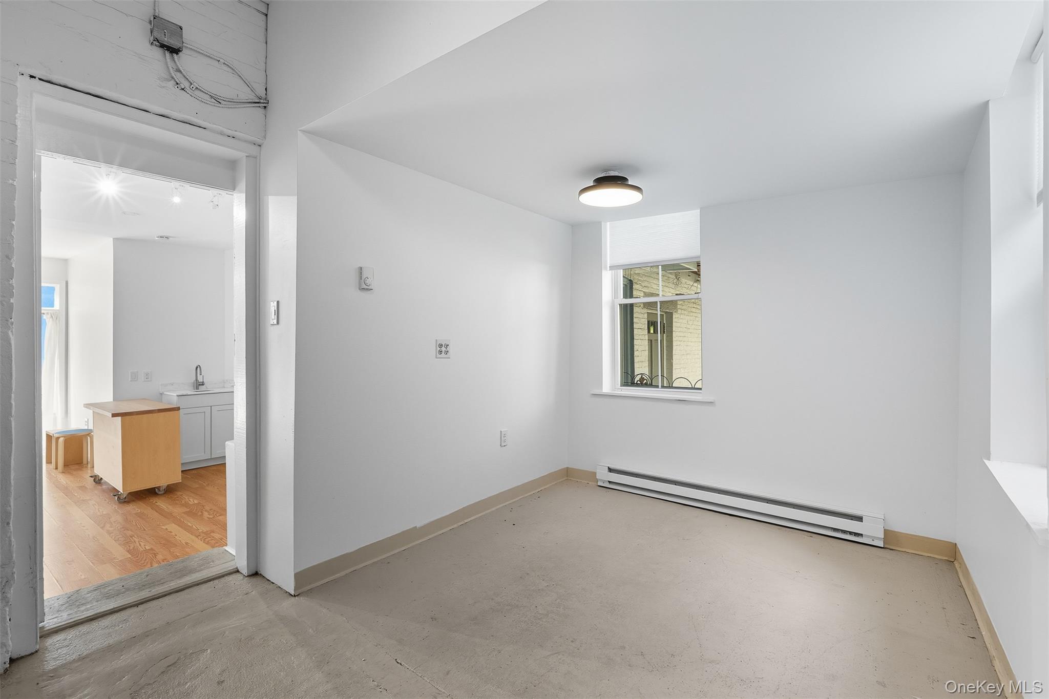Spare room with baseboard heating and concrete floors