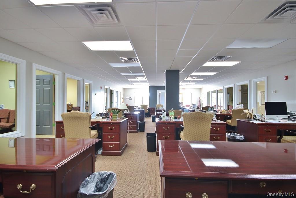 Office area with a drop ceiling and light colored carpet