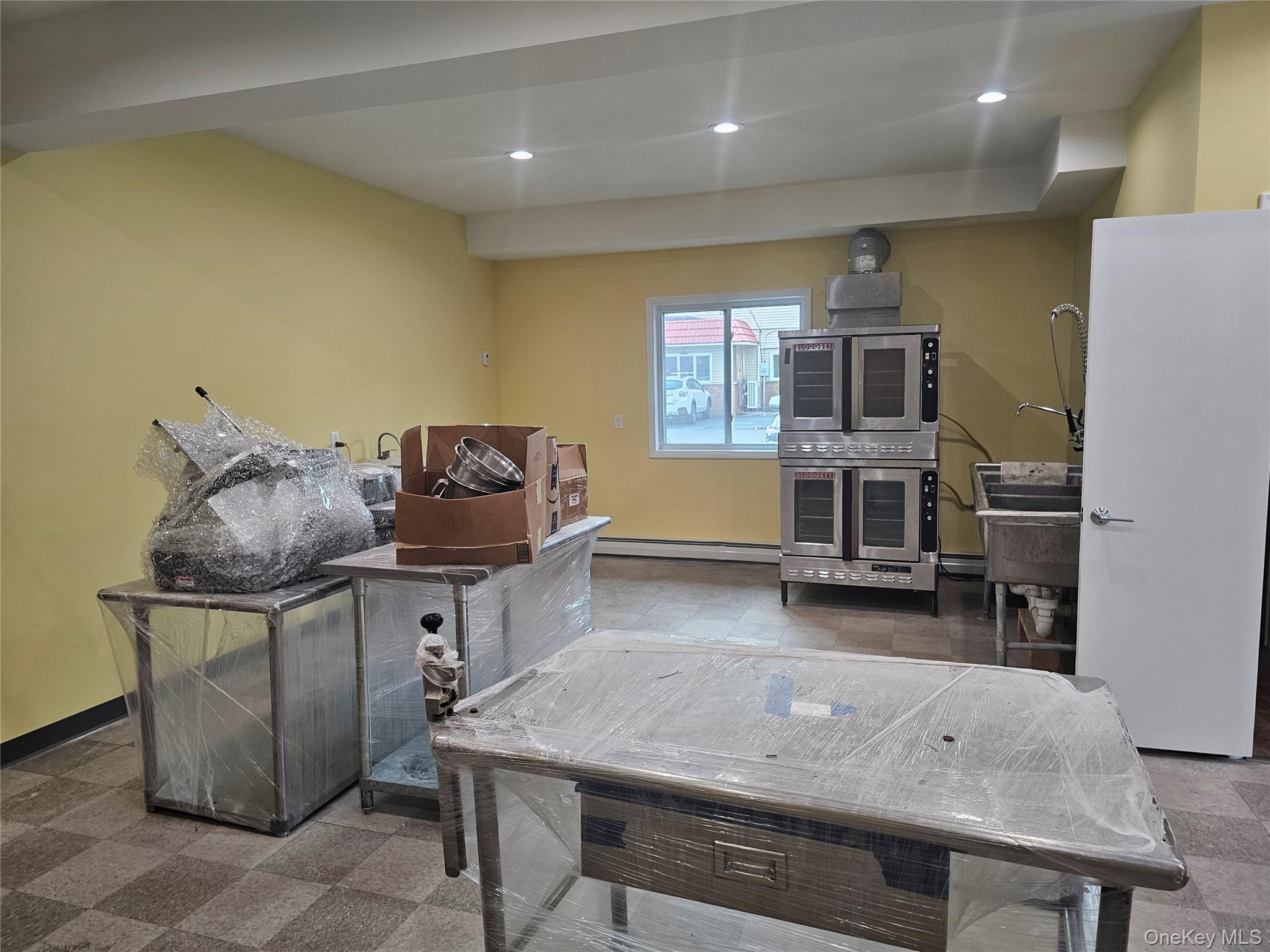 Rec room featuring recessed lighting and a baseboard heating unit