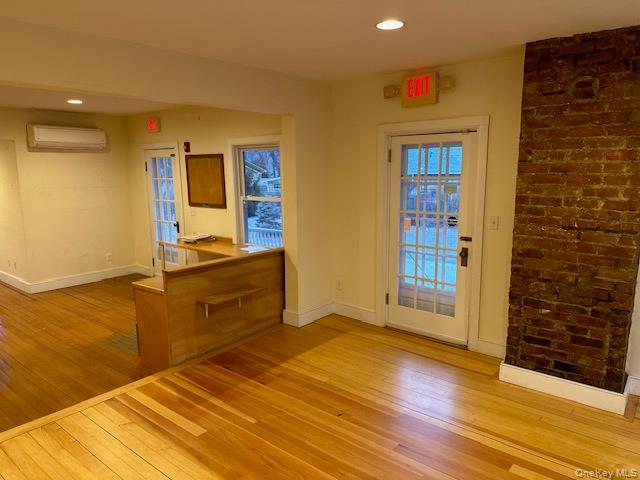 Doorway to outside featuring wood-type flooring, recessed lighting, and a wall mounted air conditioner