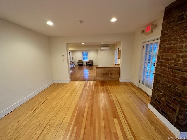 Spare room featuring light wood-style flooring, recessed lighting, and a wall mounted air conditioner