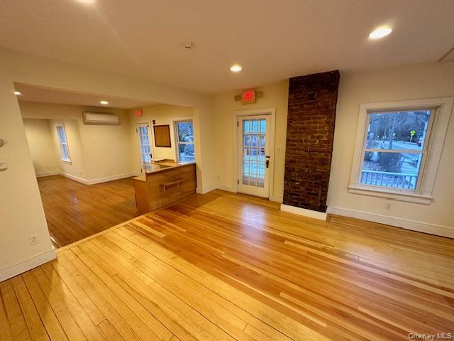 Spare room featuring light wood-type flooring, recessed lighting, and a wall mounted air conditioner