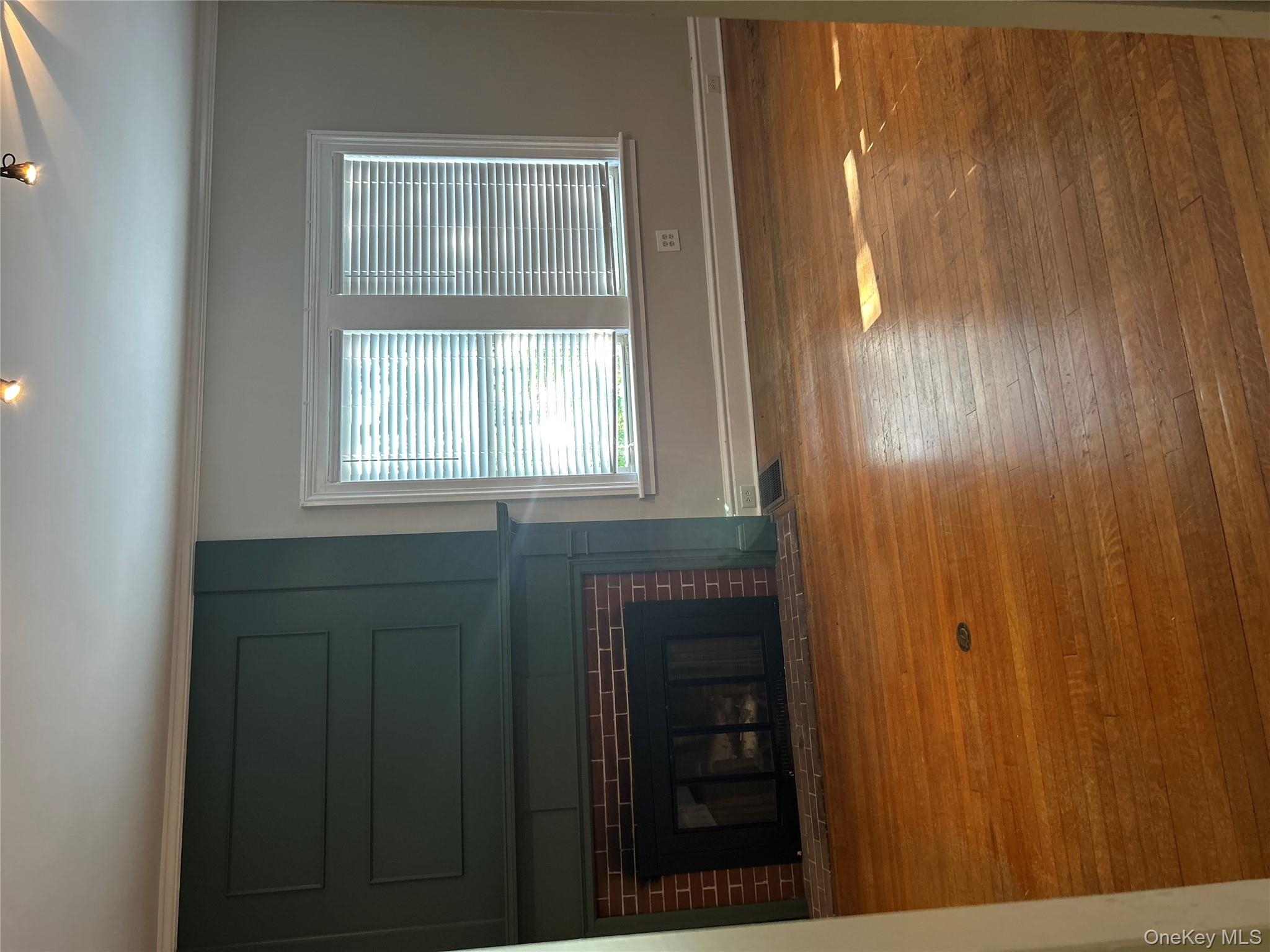 Unfurnished living room with a large fireplace, crown molding, and hardwood / wood-style flooring