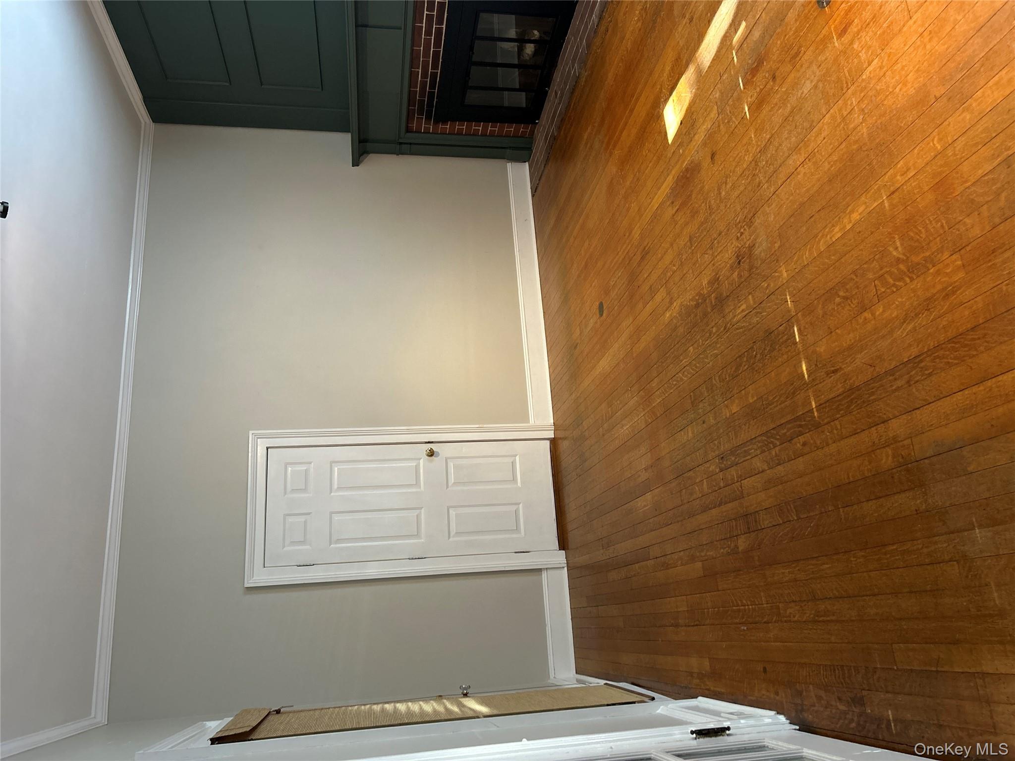 Unfurnished living room with dark wood finished floors, ornamental molding, and a fireplace