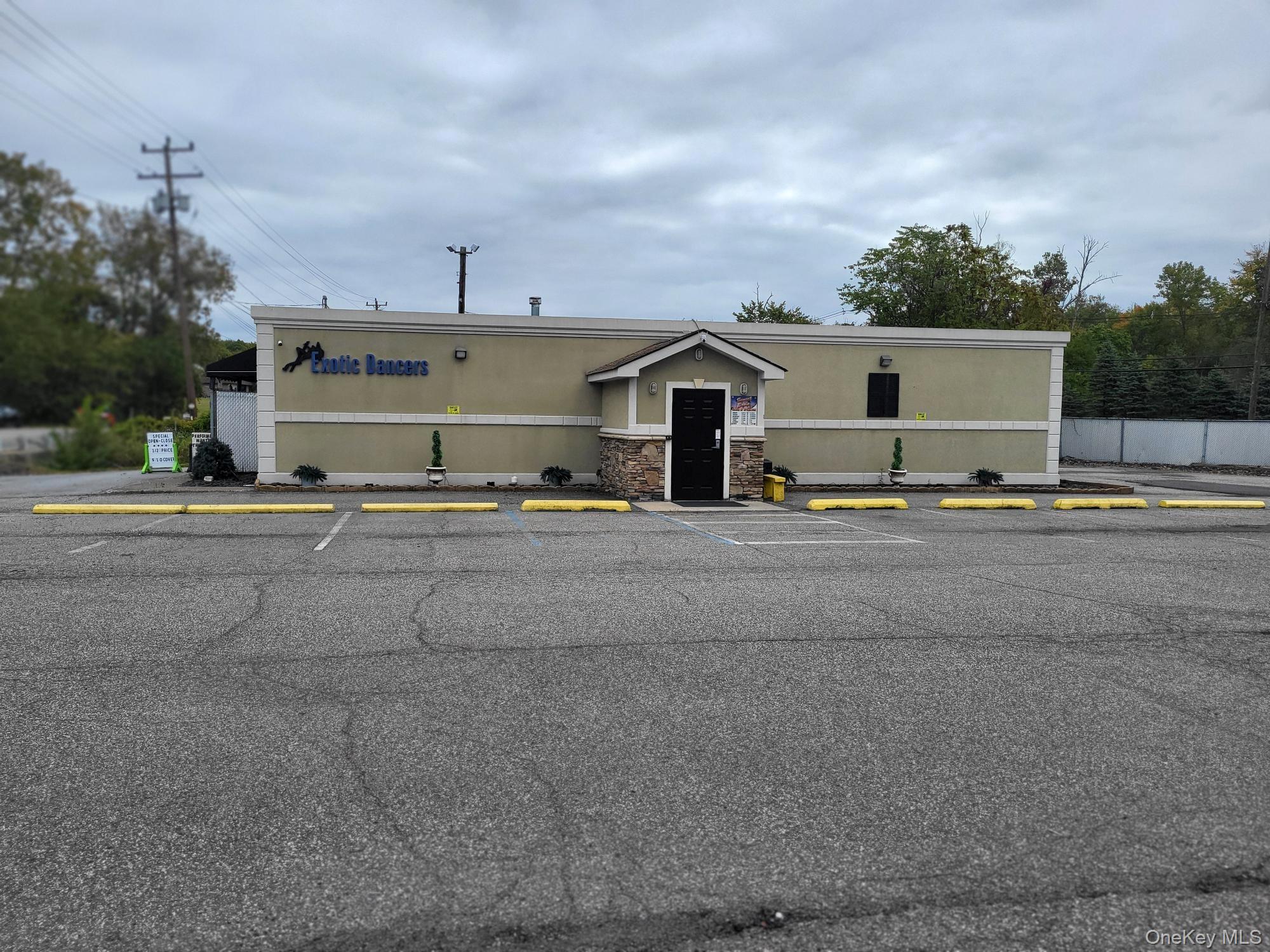 View of commercial property with uncovered parking