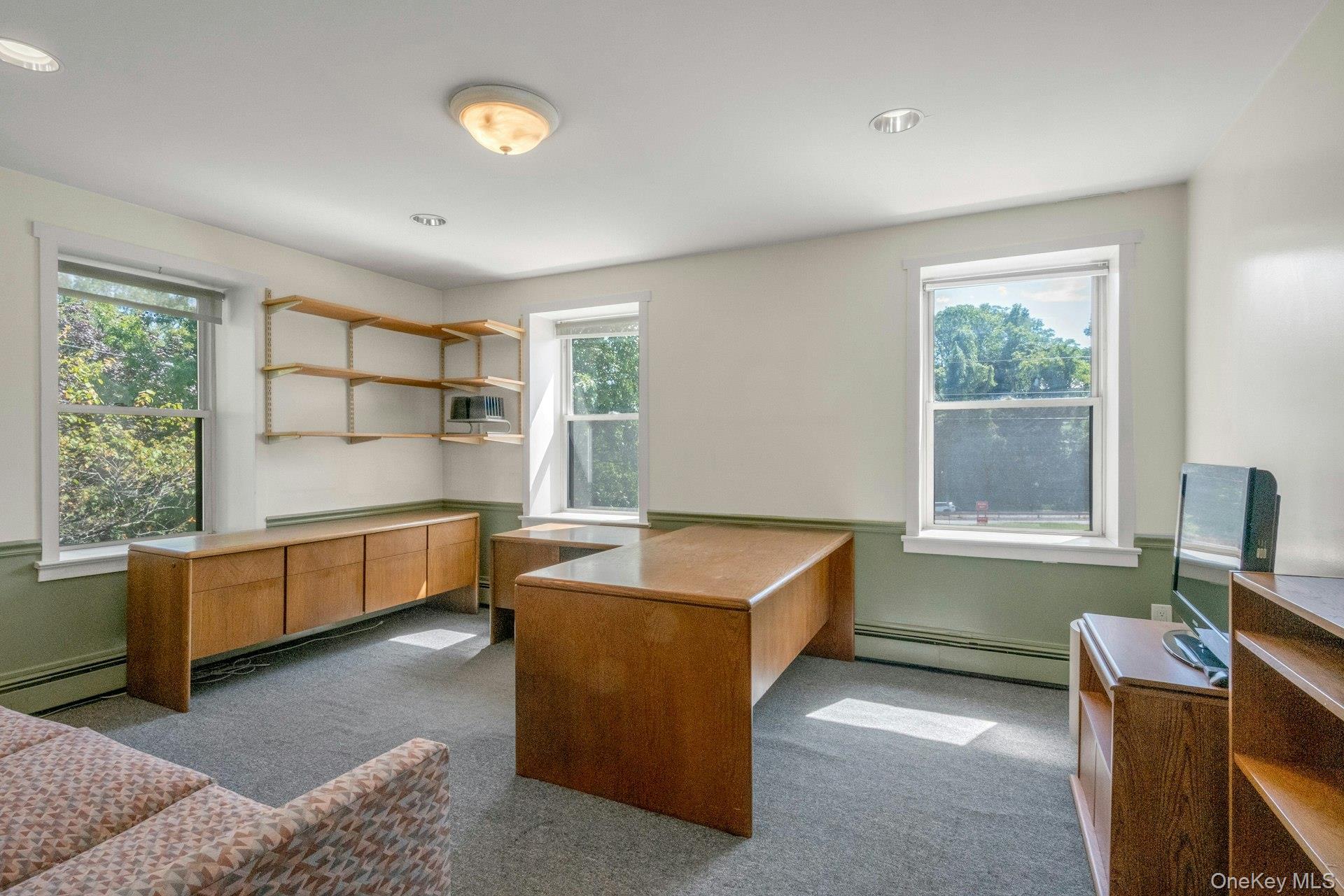 Office featuring dark colored carpet, baseboard heating, and a baseboard heating unit
