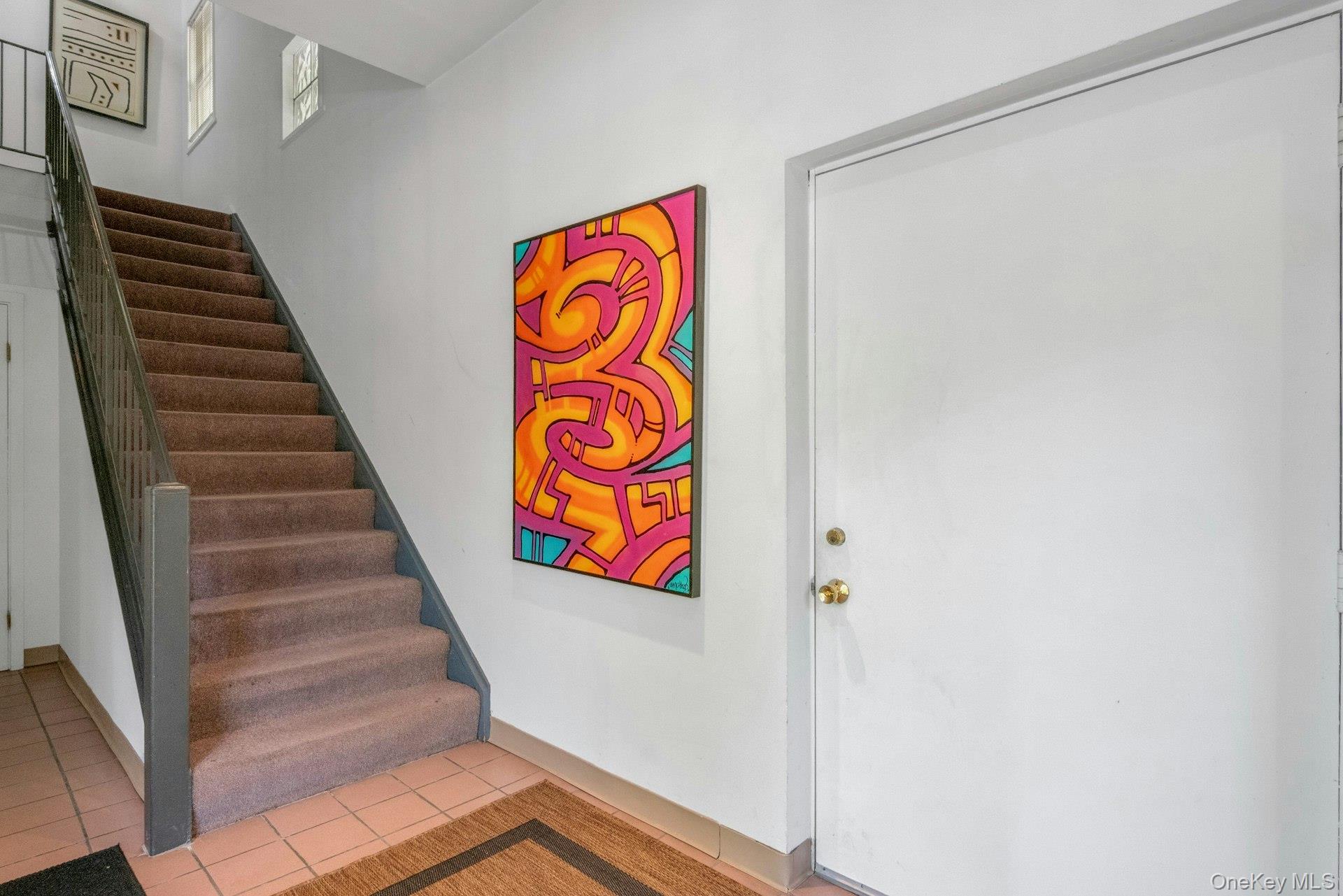 Stairway with tile patterned flooring and baseboards