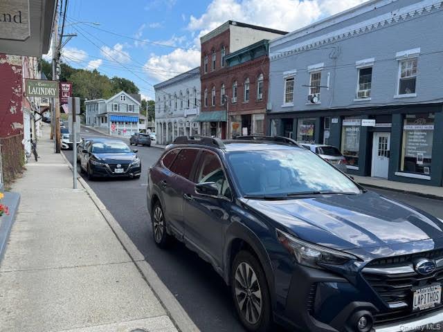 View of the street in front of the subject space with sidewalks and other stores...
