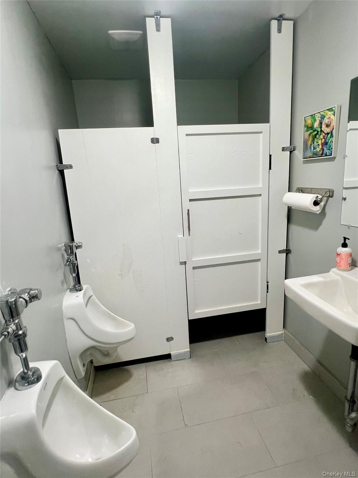 Bathroom with a bidet and light tile patterned flooring