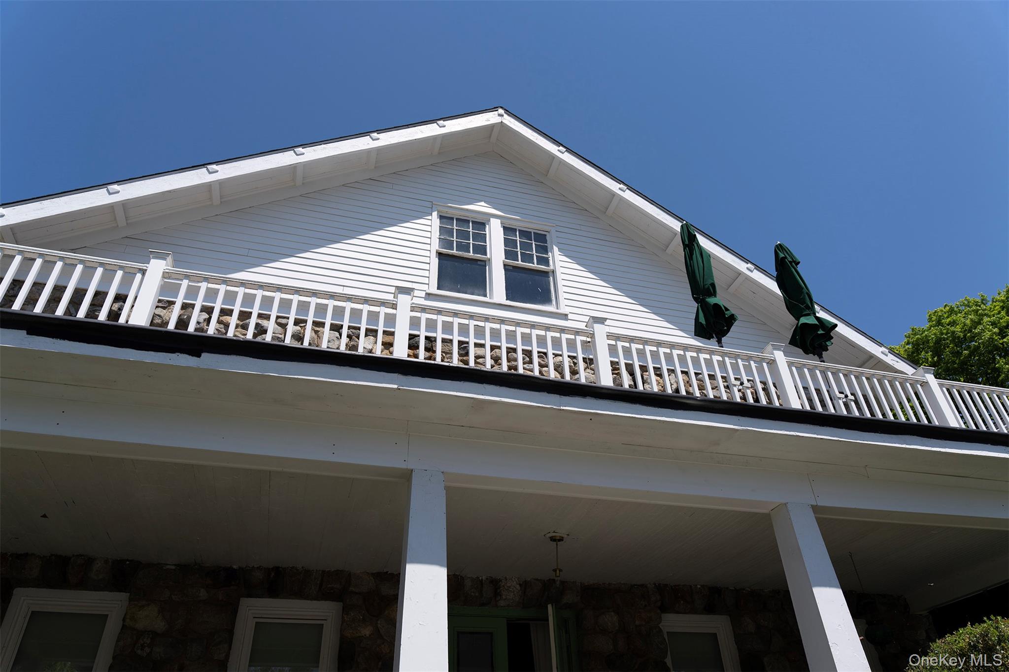 View of property exterior featuring a balcony and stone siding