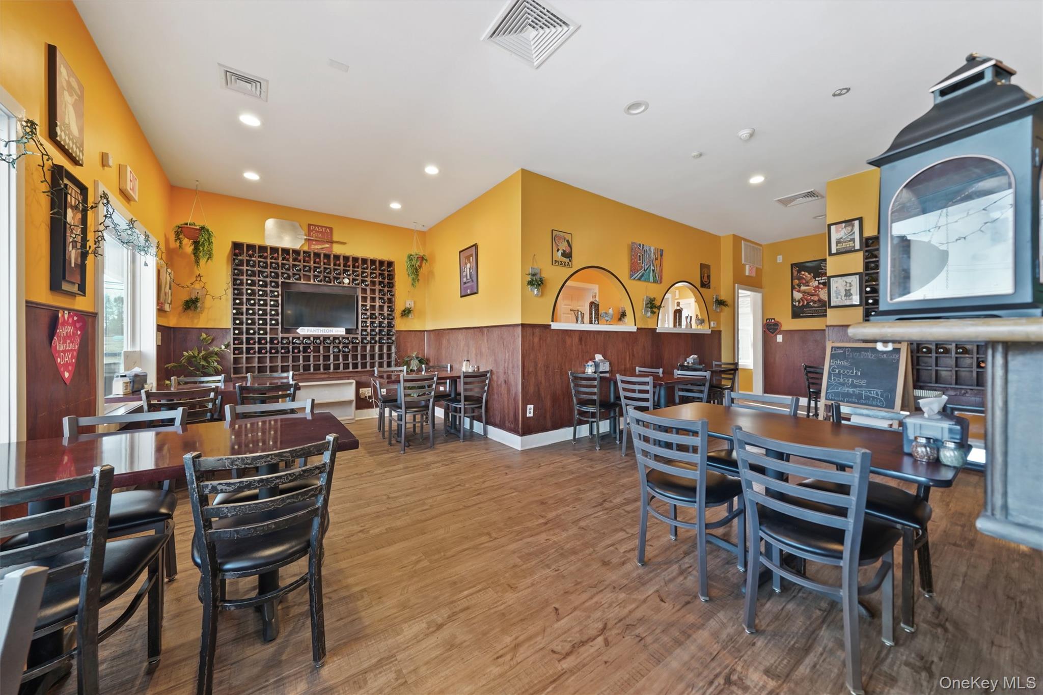 Dining area featuring wood finished floors, recessed lighting, and a wainscoted wall