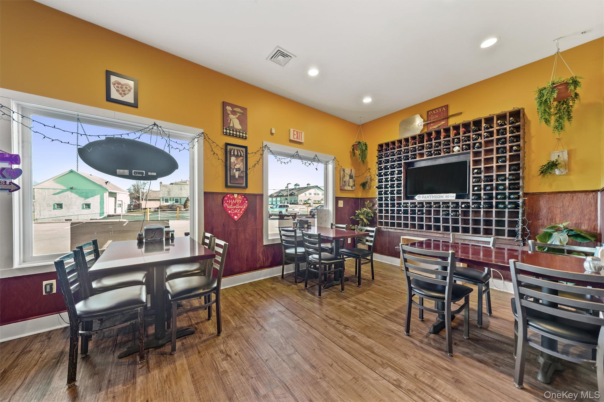 Dining room featuring wood finished floors, recessed lighting, and wainscoting