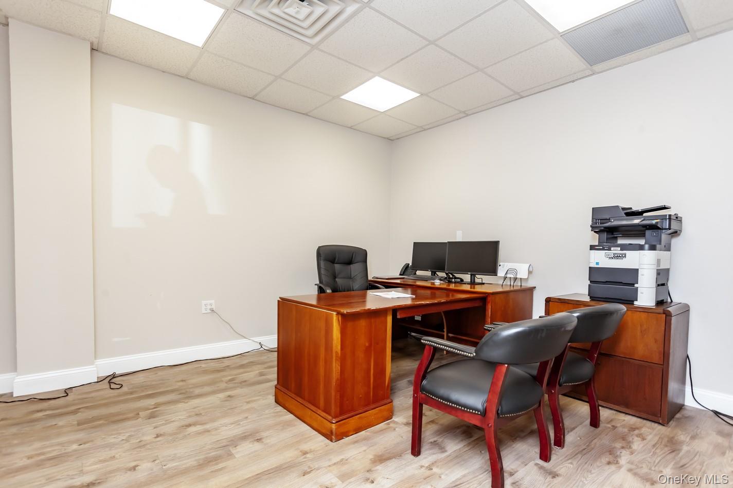 Office space featuring a paneled ceiling and light wood-type flooring