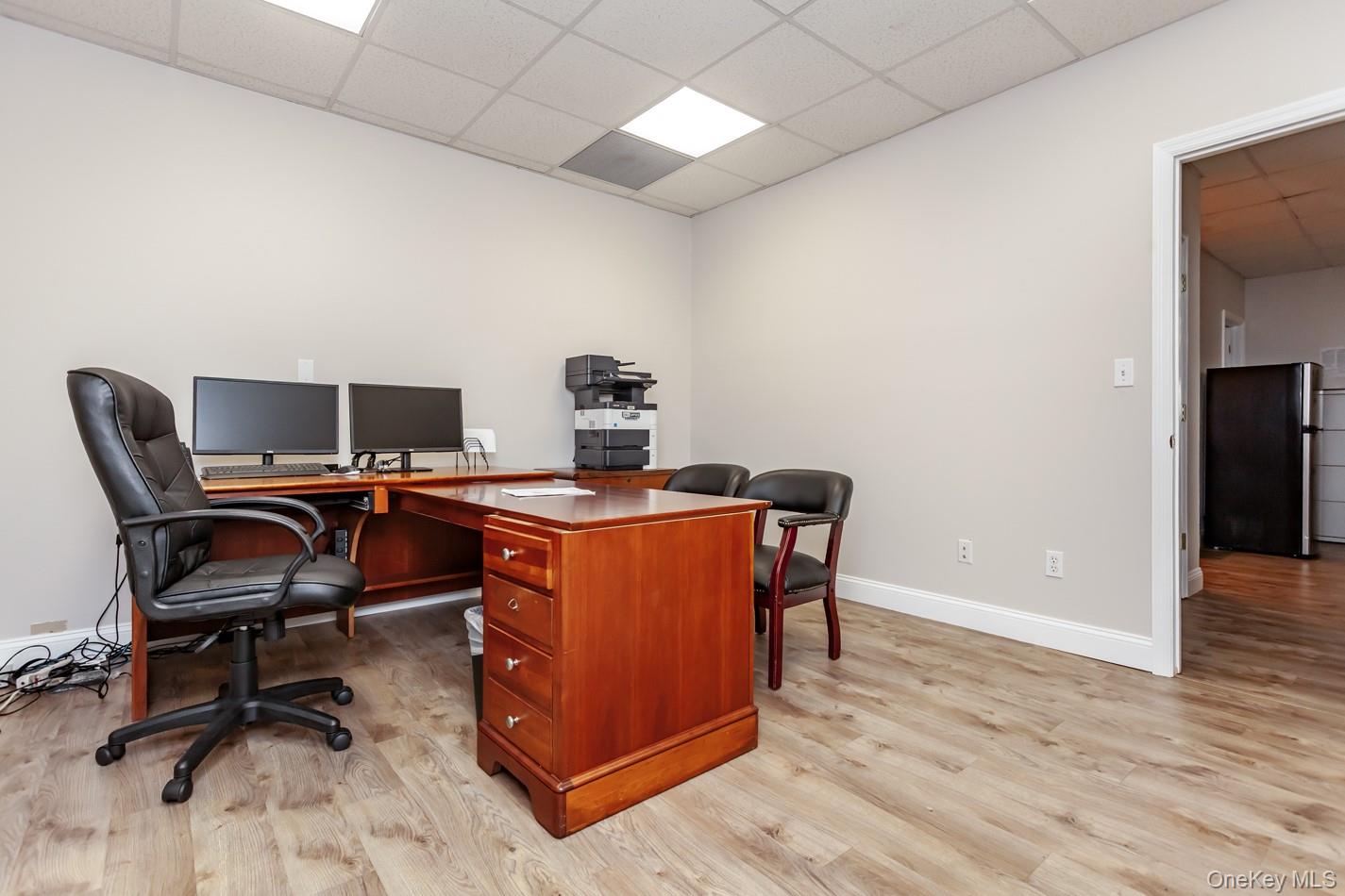 Office area featuring a paneled ceiling and light wood-type flooring