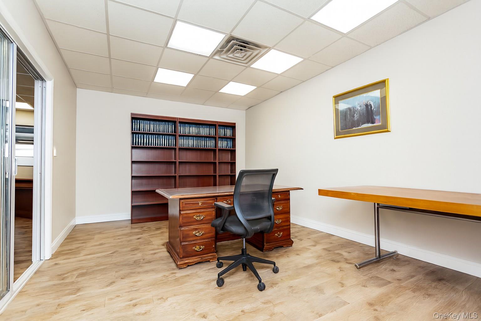 (Digitally Decluttered) Office space featuring a drop ceiling and light wood-type flooring
