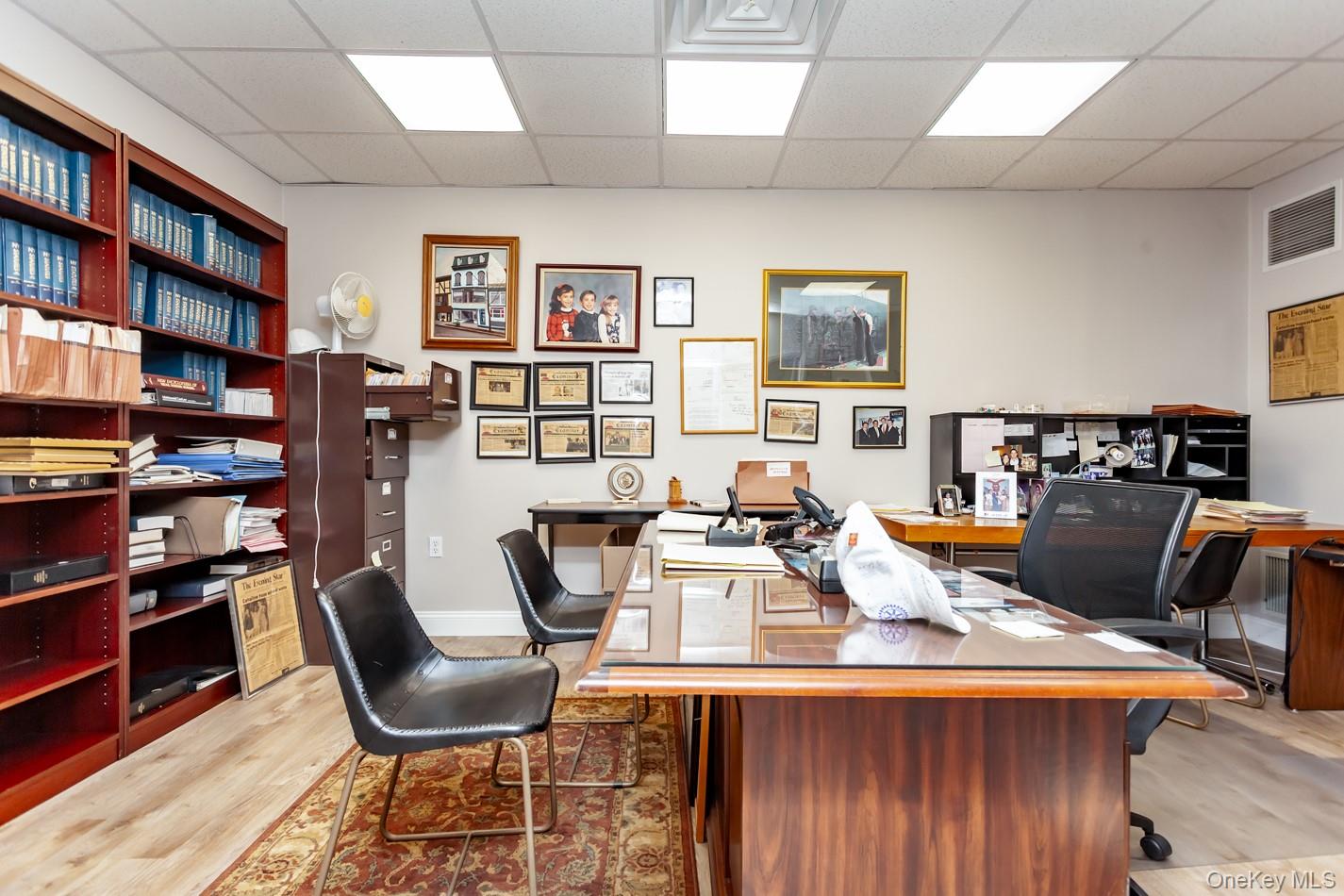 Office with a paneled ceiling and light wood finished floors