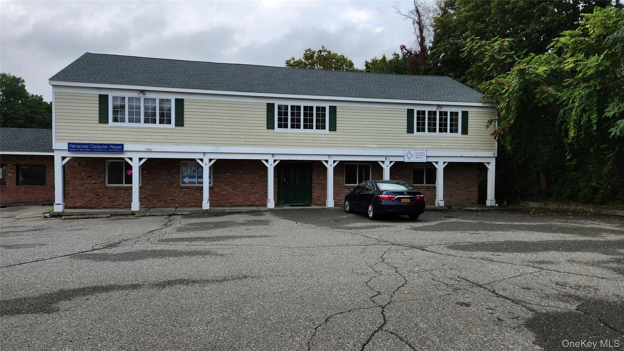 View of front of property featuring brick siding and a shingled roof