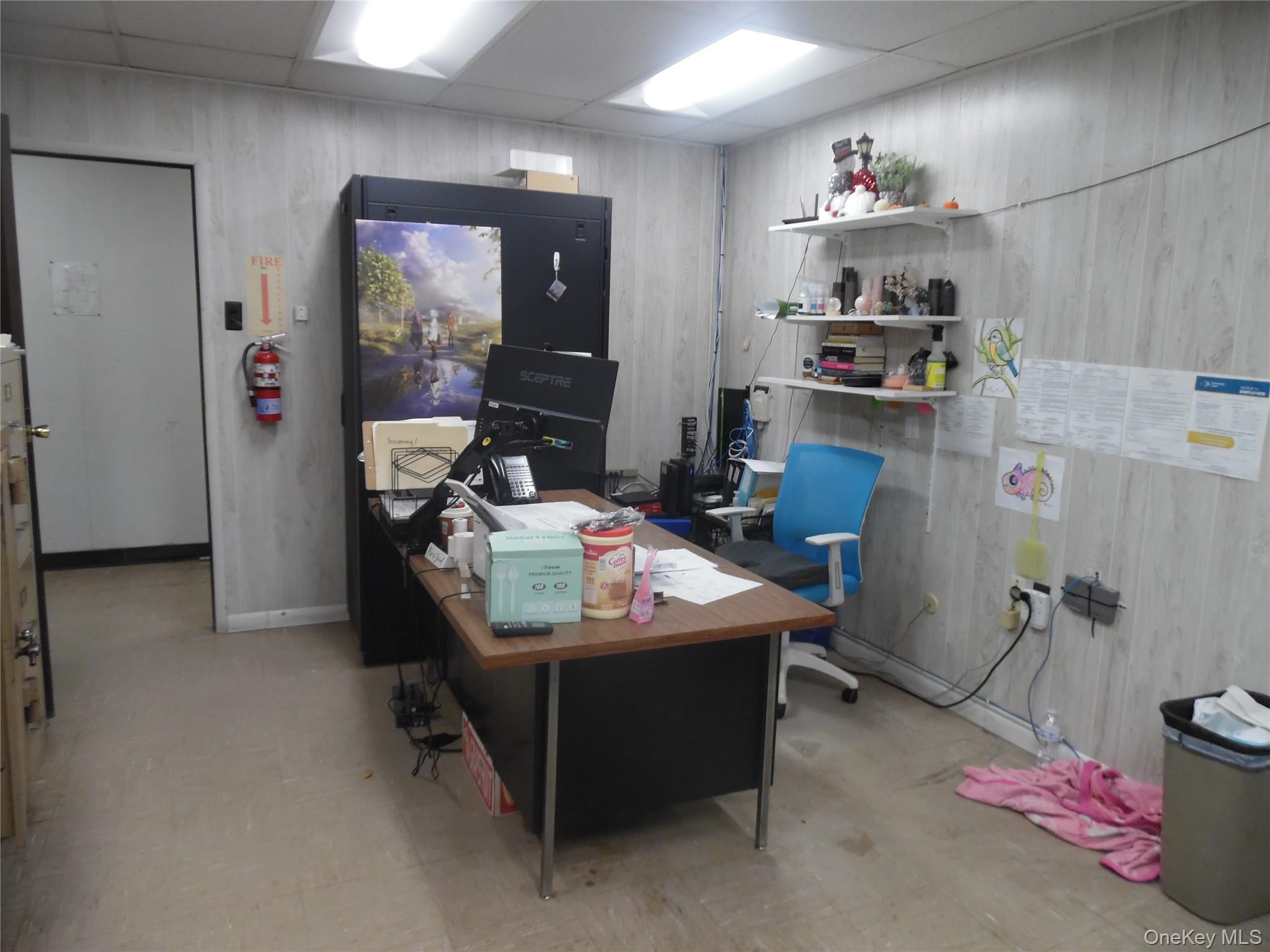 Home office with a drop ceiling and light flooring