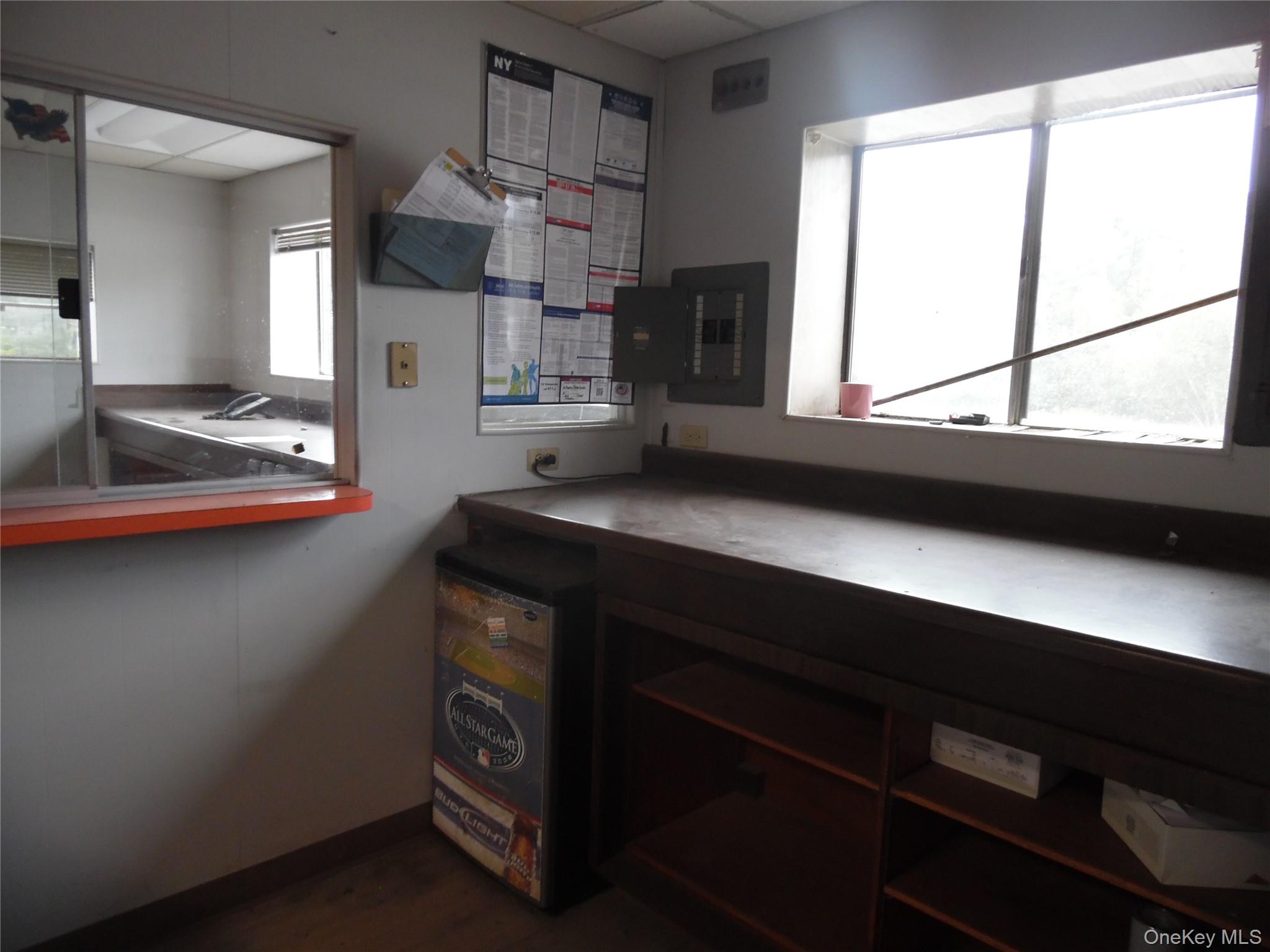 Office featuring healthy amount of natural light, electric panel, and dark wood-style floors