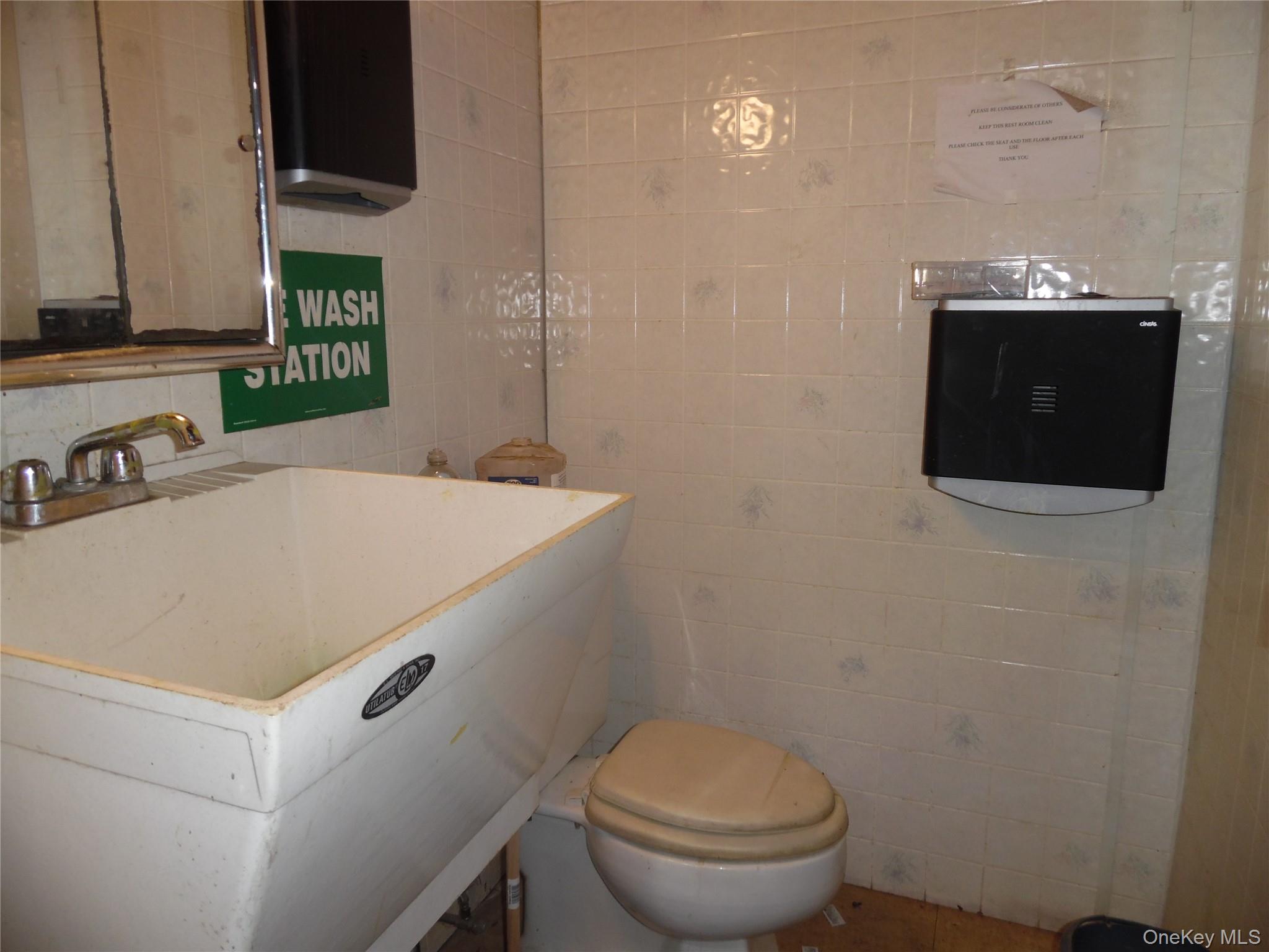Half bathroom with tile walls and a sink