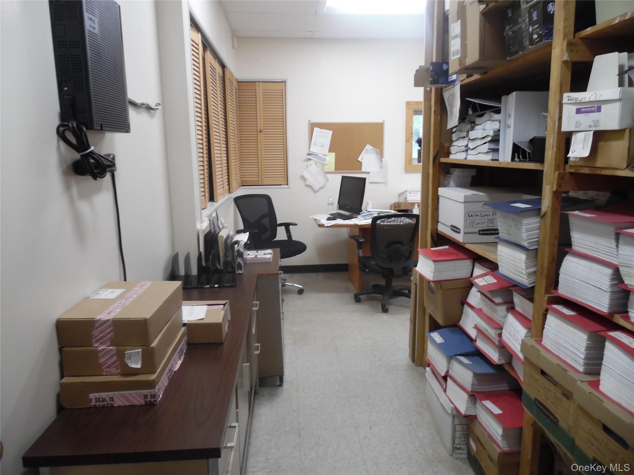 Office area featuring light flooring and baseboards