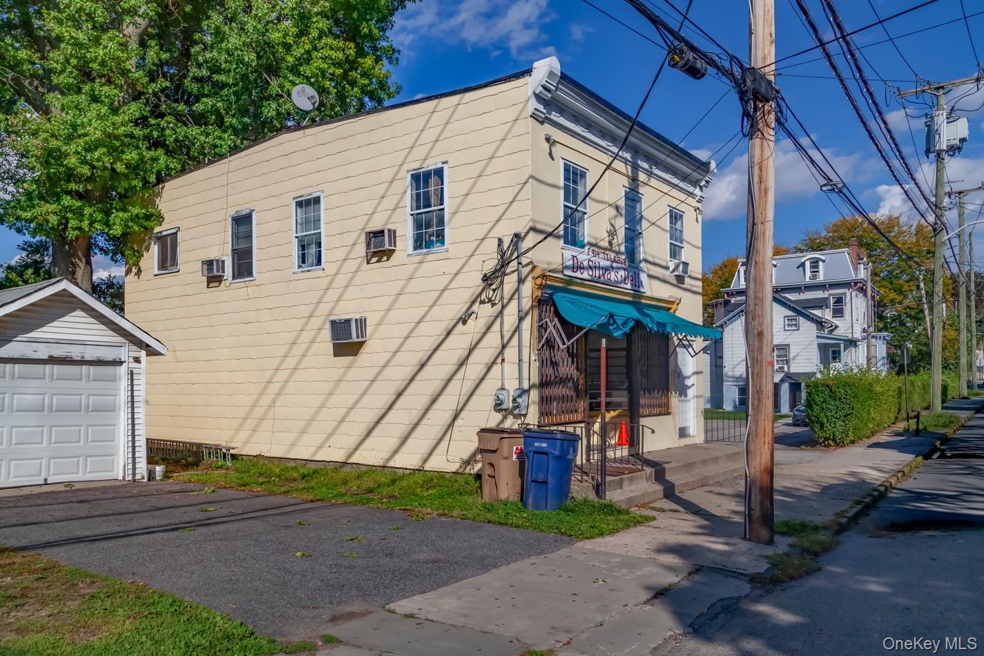 View of home's exterior featuring an outdoor structure, a detached garage, and a wall unit AC
