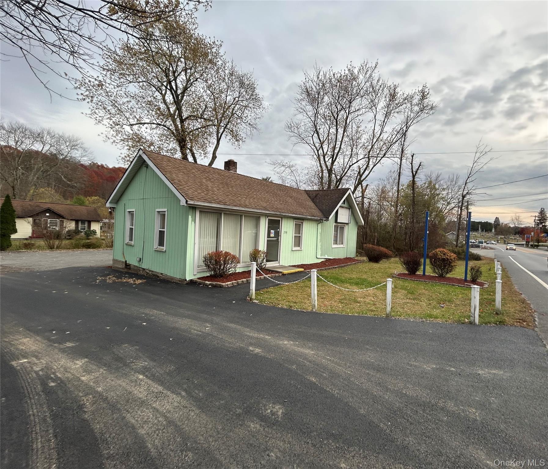 View of front of property with a chimney, a front lawn, and a shingled roof