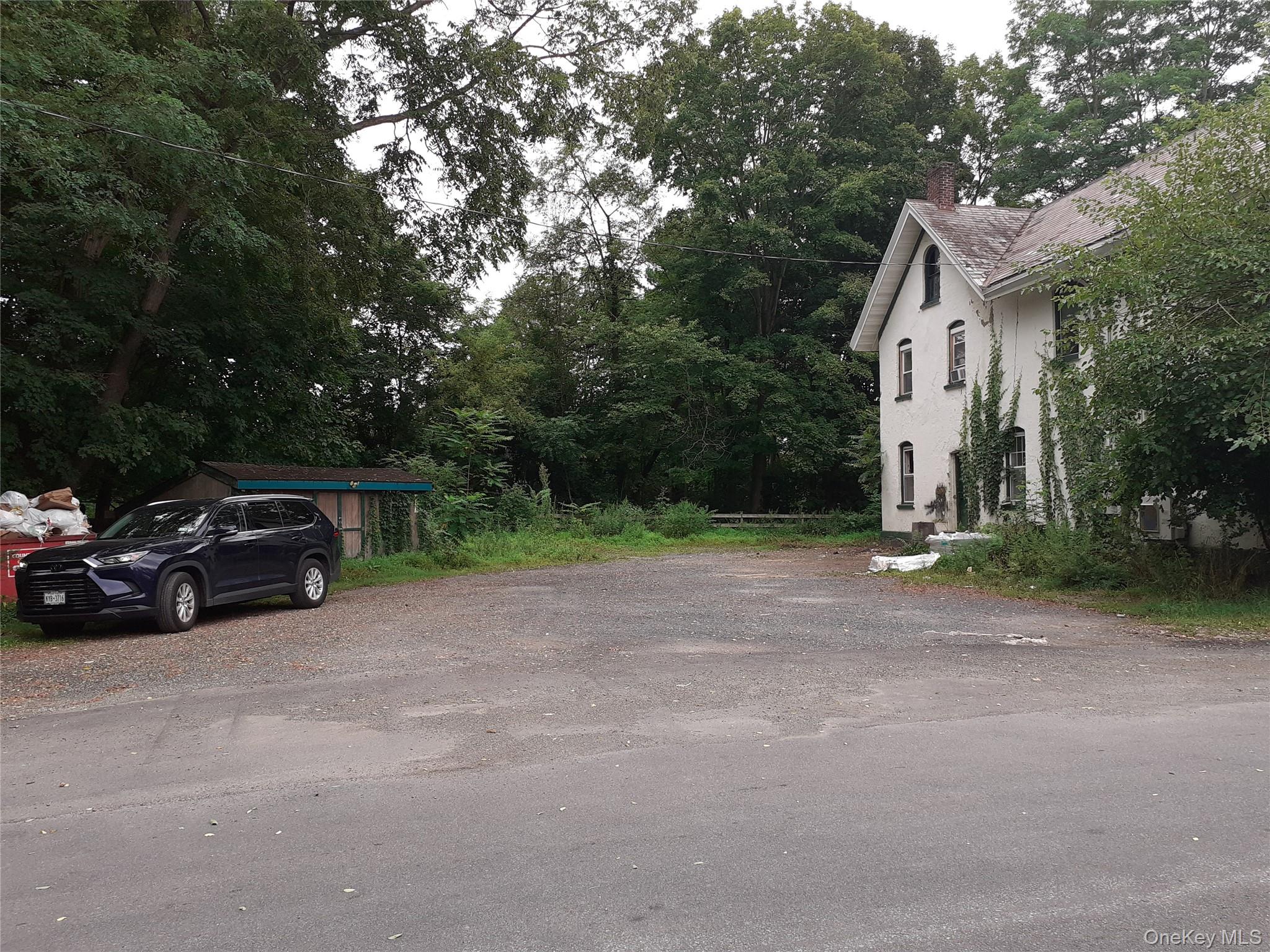 View of property exterior with a chimney and view of wooded area