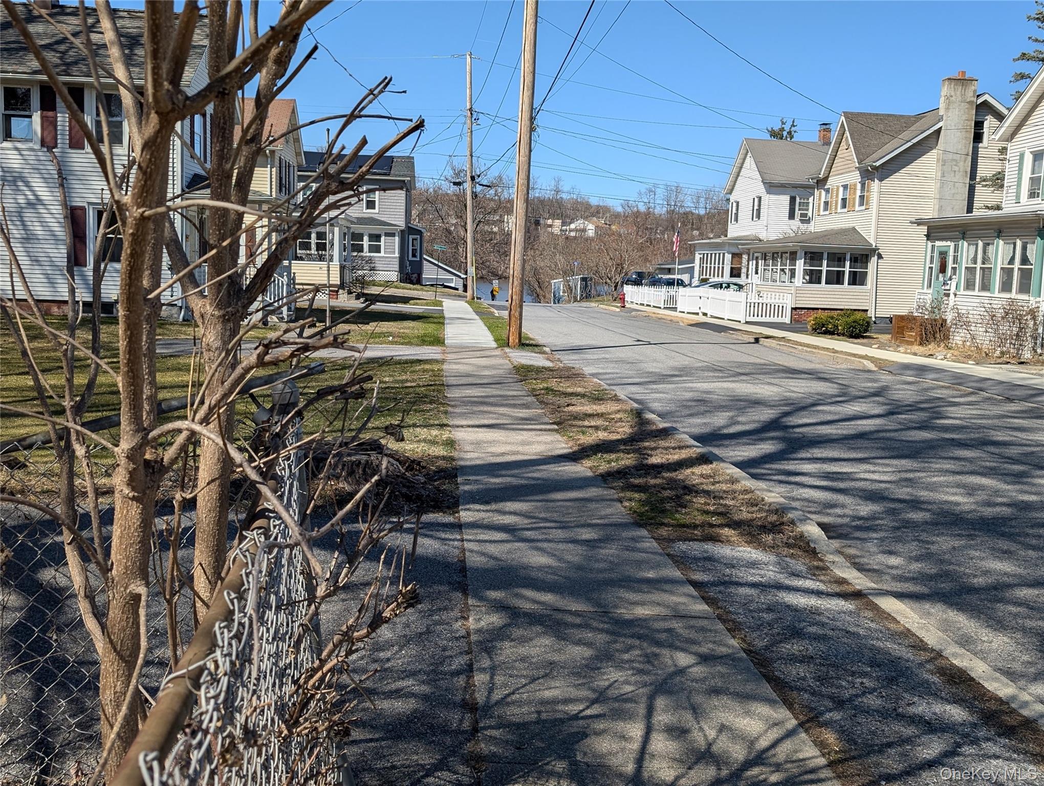 View of asphalt street featuring a residential view, sidewalks, and curbs
