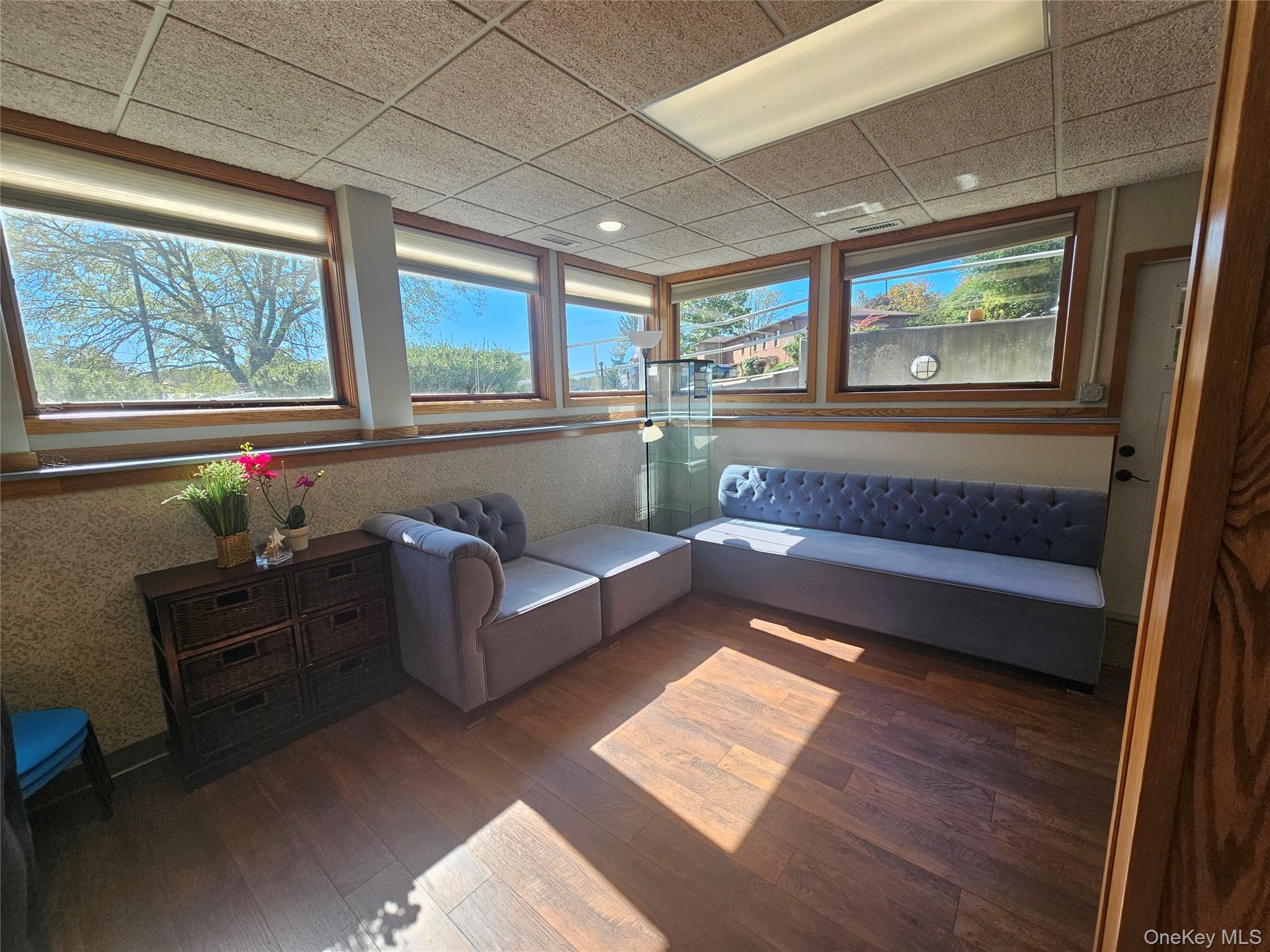 Living area with wood-type flooring and a paneled ceiling