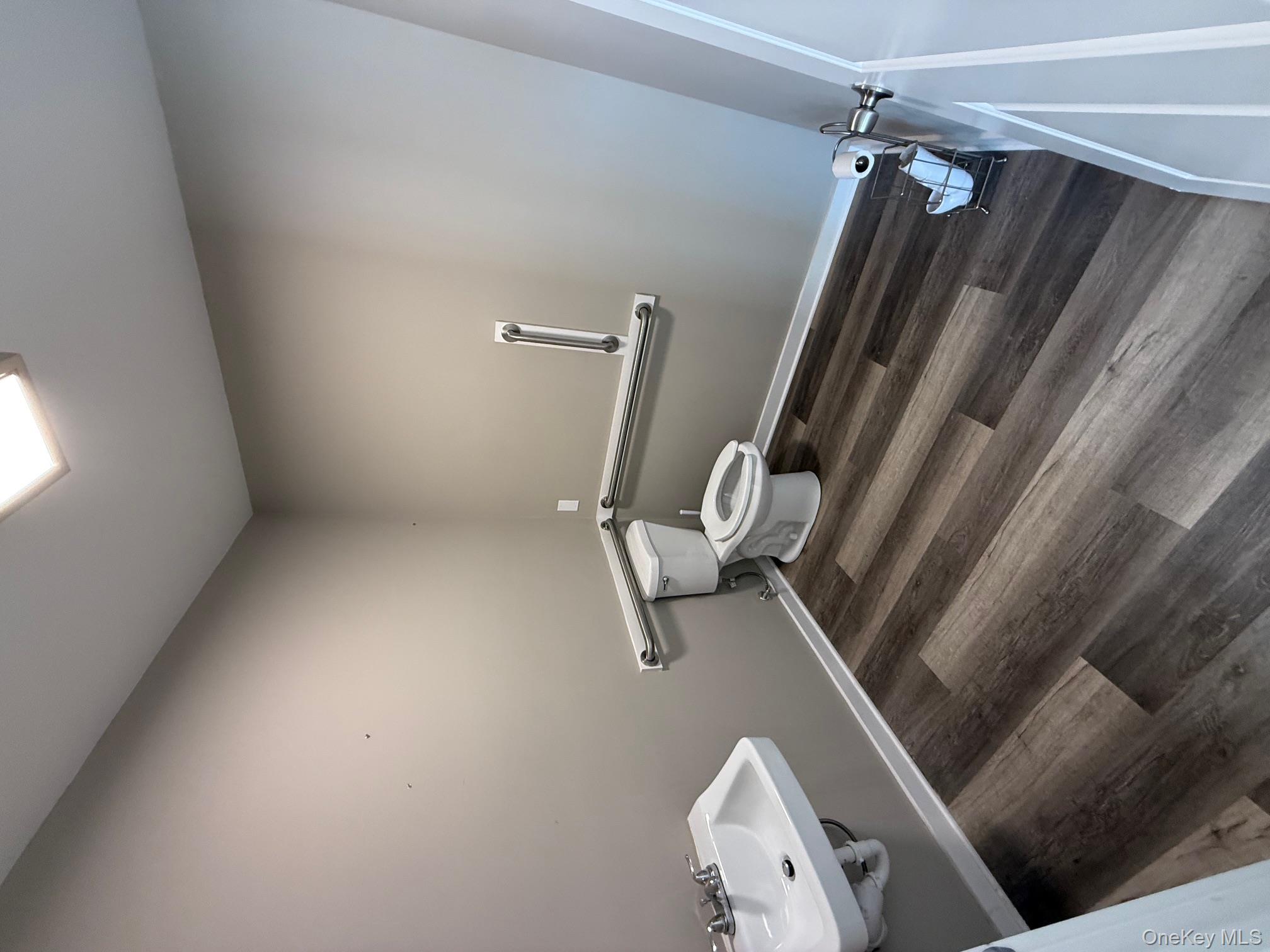 Half bathroom with toilet and dark wood finished floors