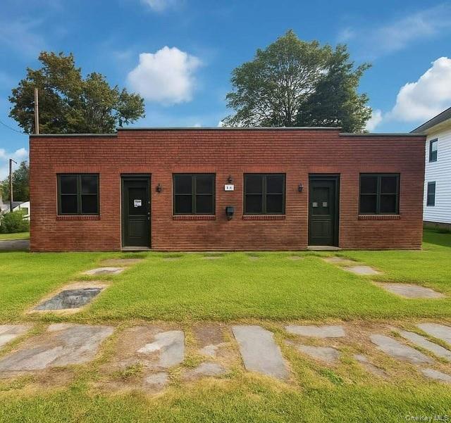 View of front of house with a front yard and brick siding