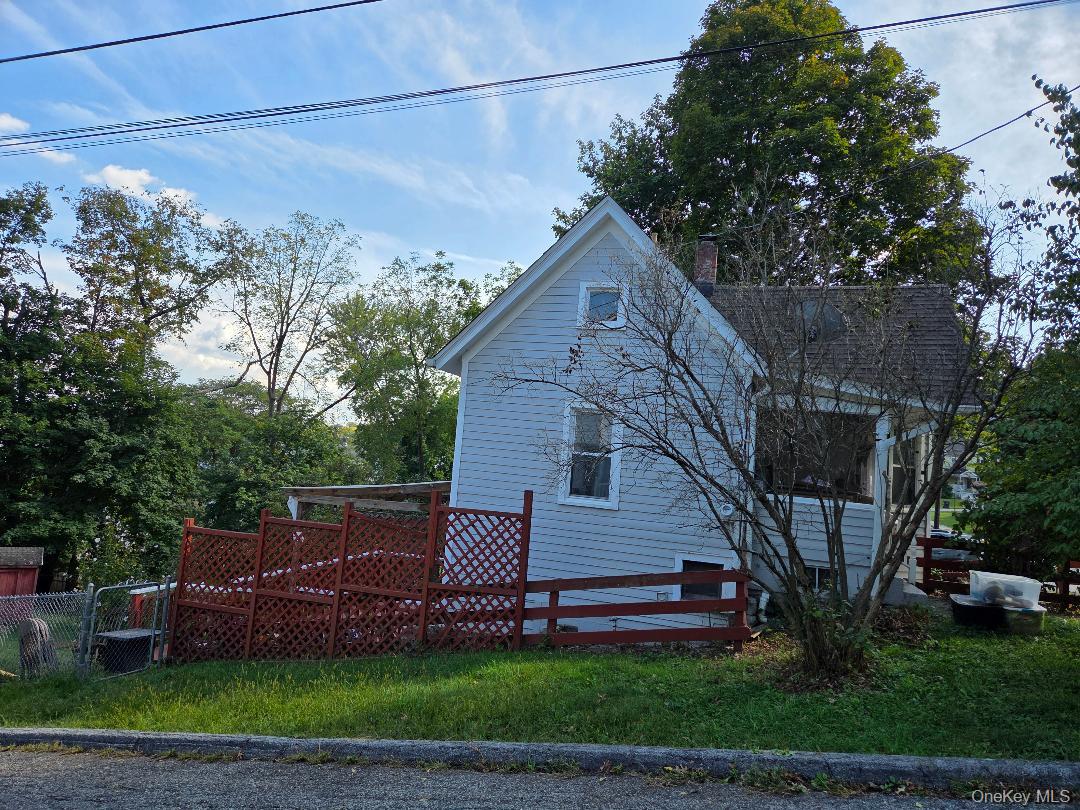 View of side of property featuring a chimney and a wooden deck