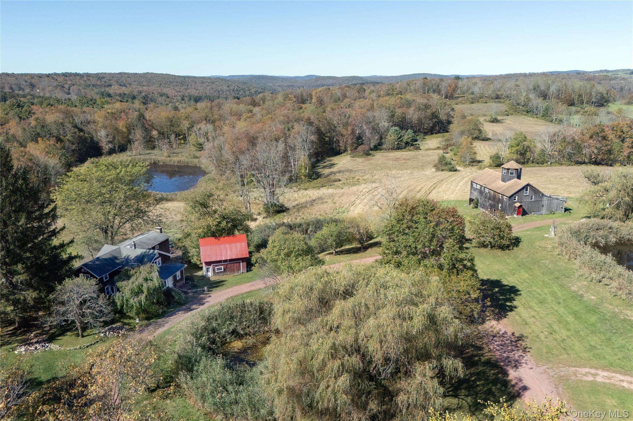 View from above of property with a pond and a wooded area