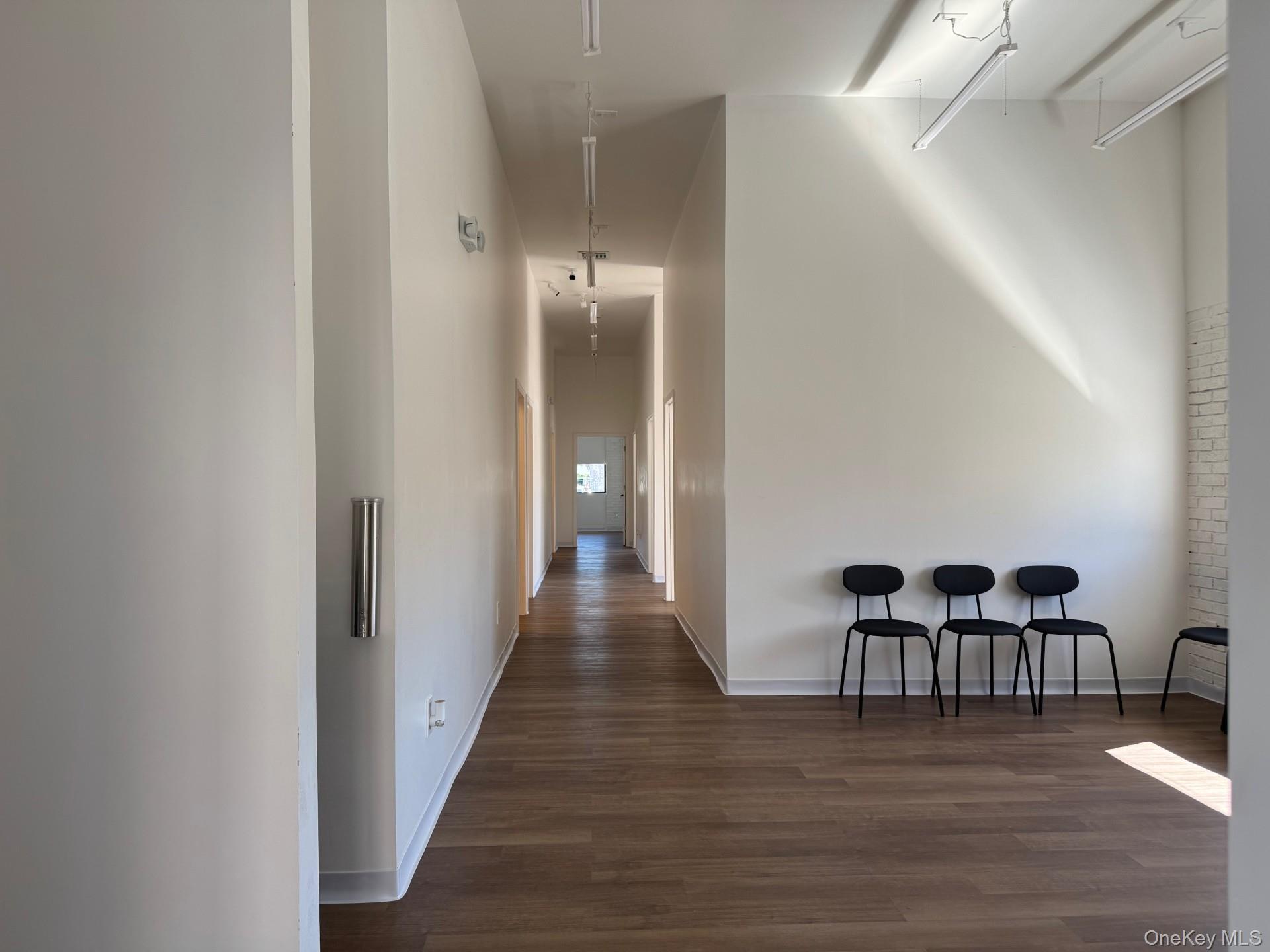 Hall featuring dark wood-style floors and attic access