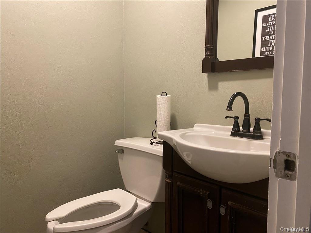 Bathroom featuring a textured wall and vanity