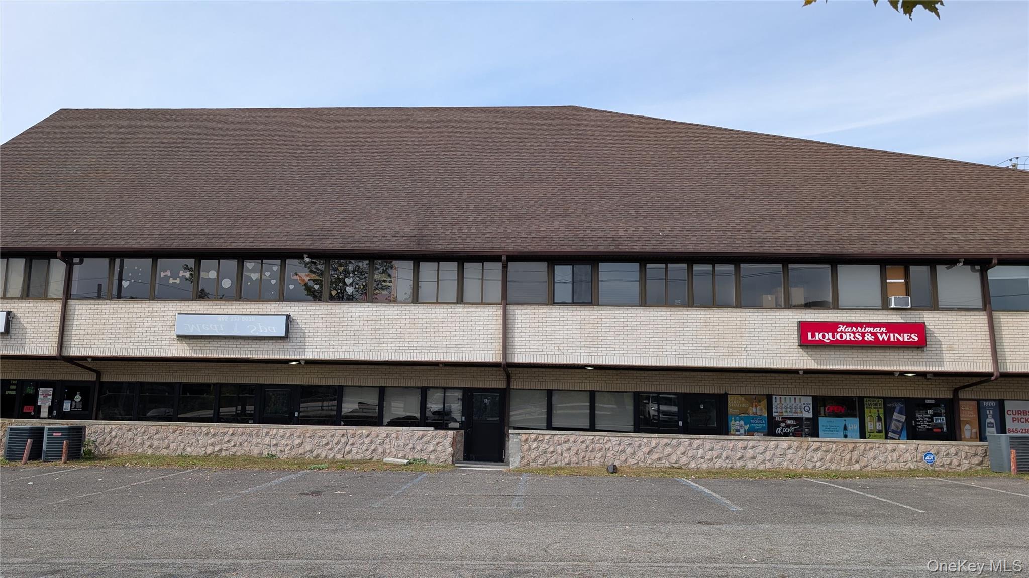 View of commercial property with uncovered parking