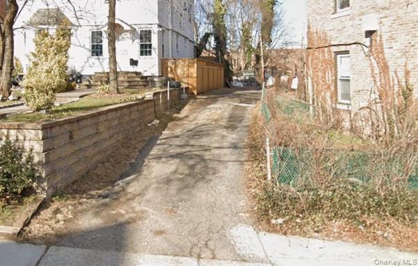 View of side of home with driveway and brick siding