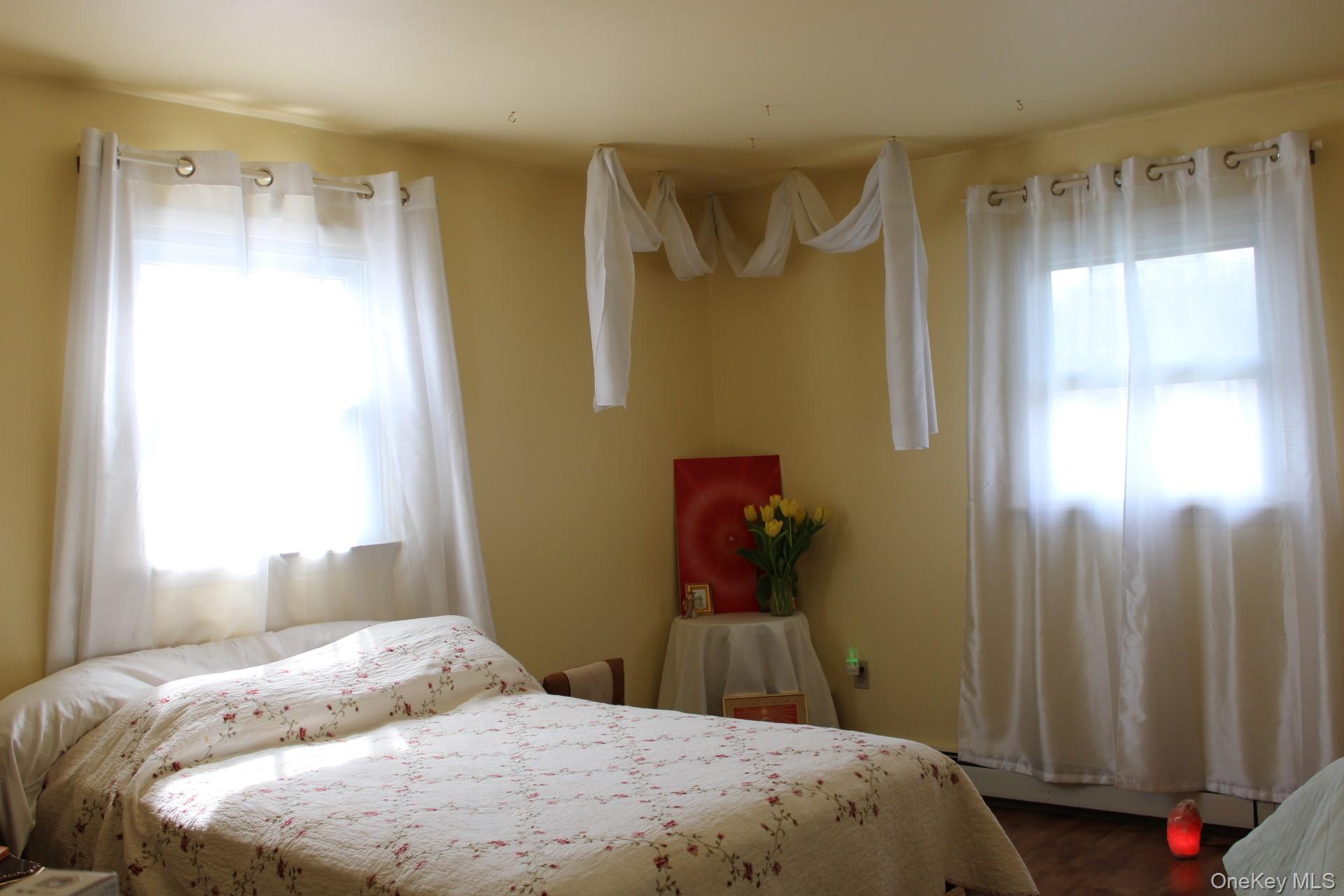 Bedroom with dark wood-style flooring