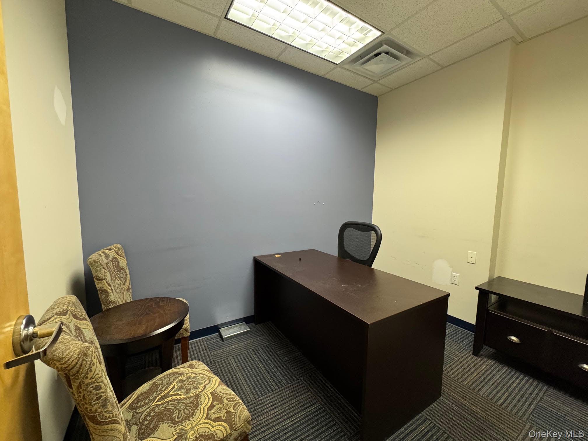 Office featuring a drop ceiling and dark carpet