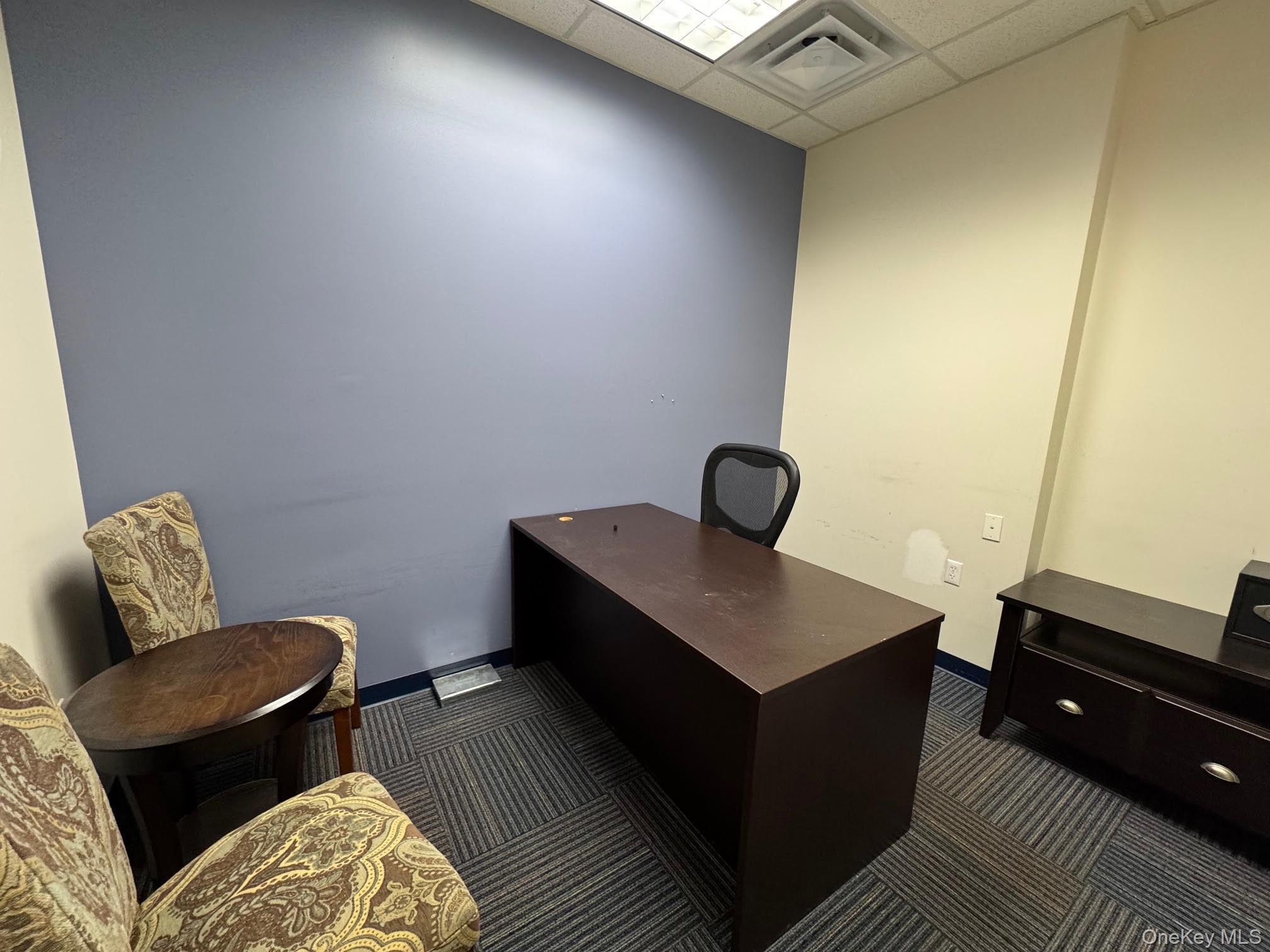 Office area with drop ceiling and dark carpet