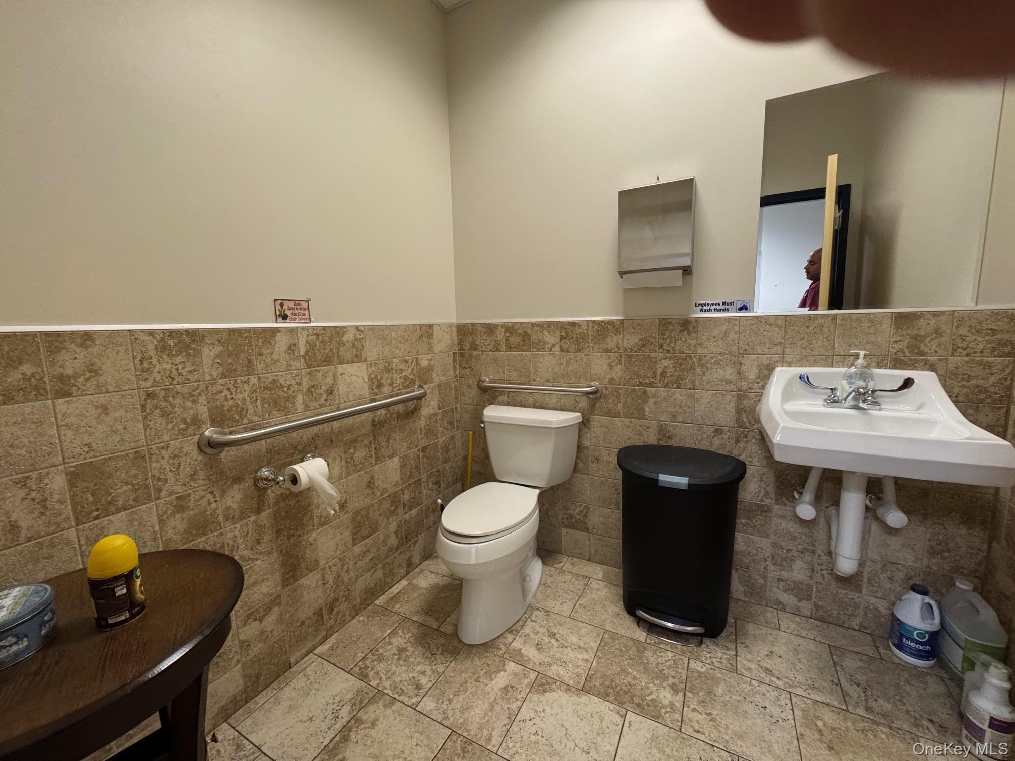 Half bathroom with tile walls, and tile patterned floors