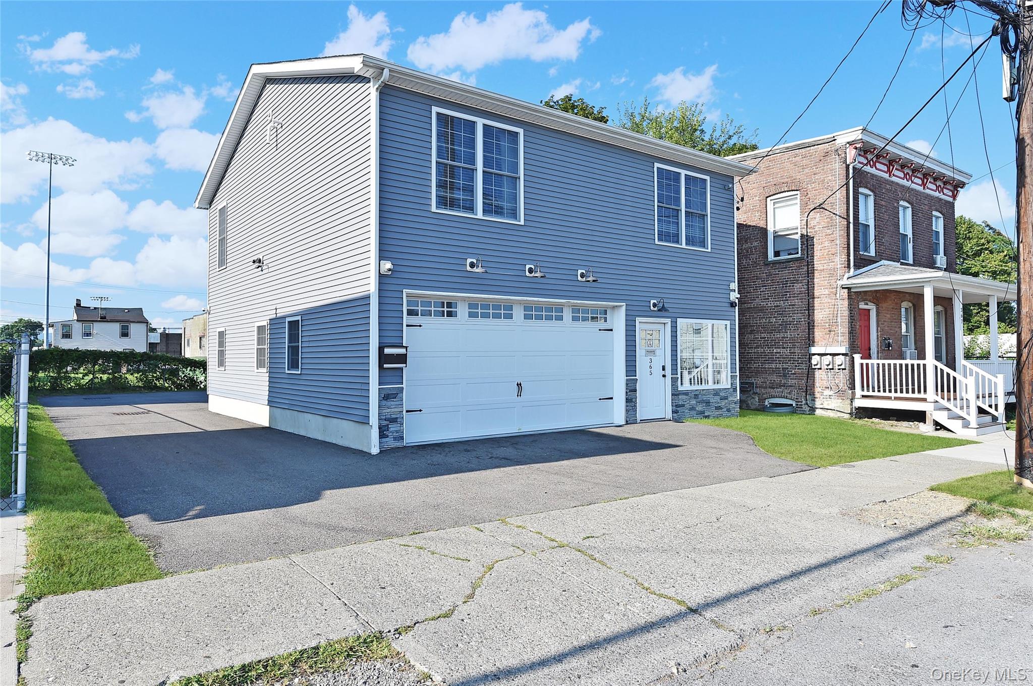View of front facade with asphalt driveway and a garage