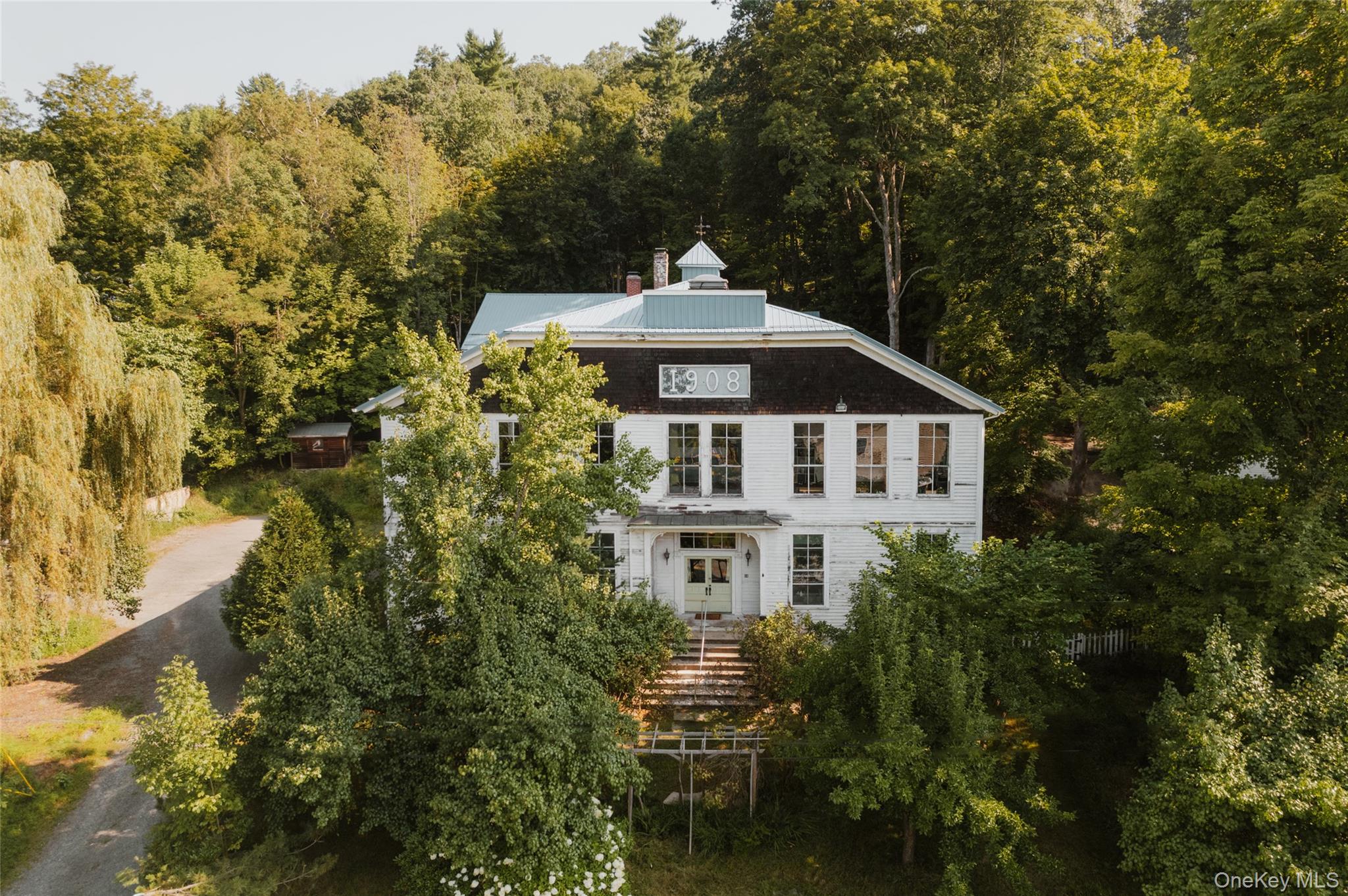 Back of property featuring a wooded view